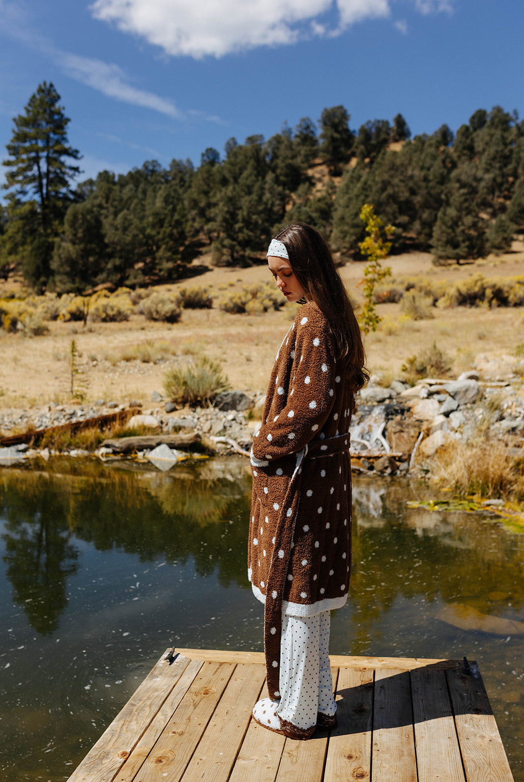 Side and back view of the brown fluffy polka dot robe on a dock.