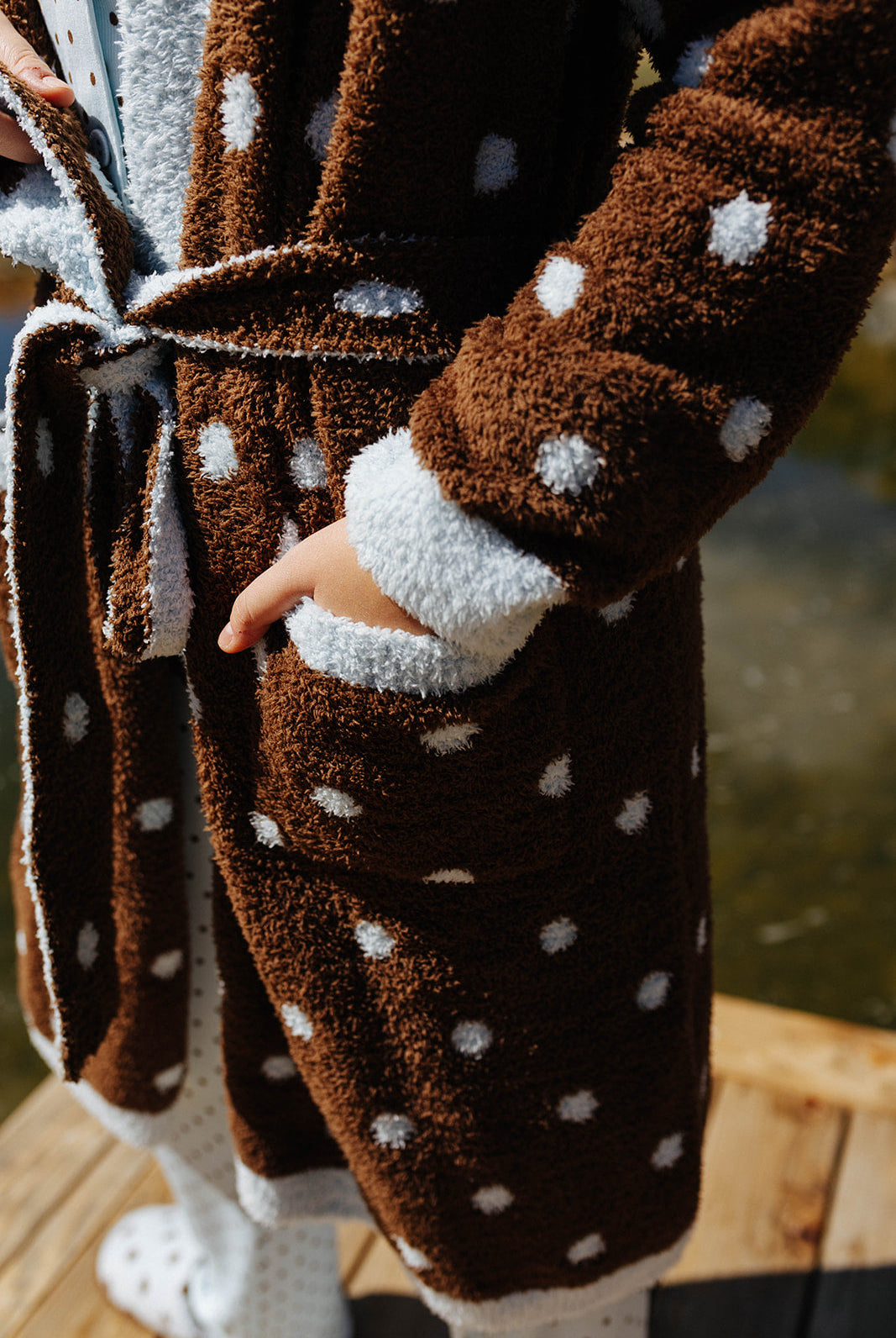 Close view of the brown polka dot robe tied at the waist.