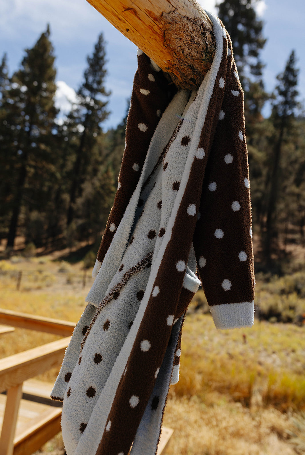Close view of the polka dot robe hanging over the back of a wooden chair.