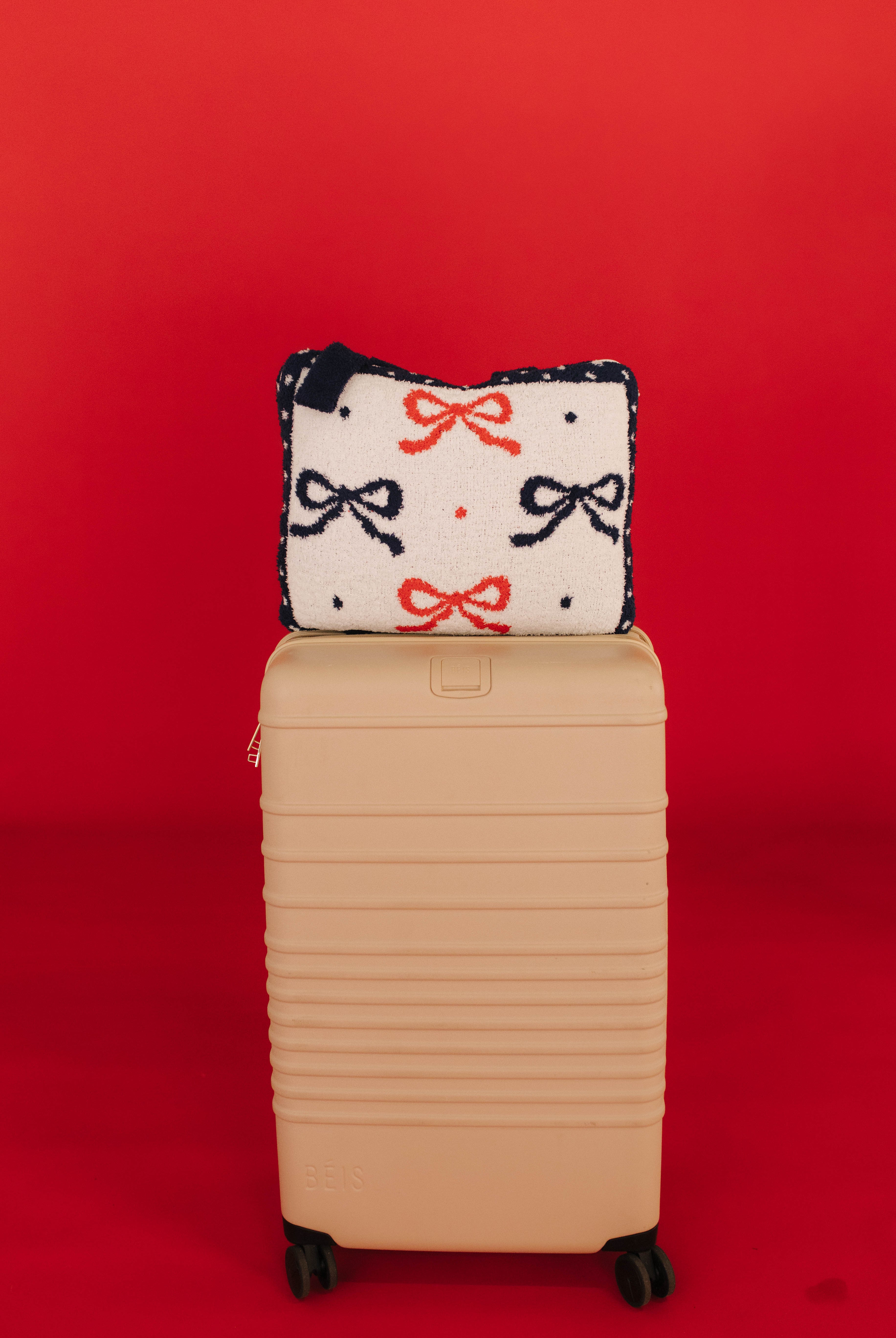 quillow cover with bows and polka dots on beis suitcase