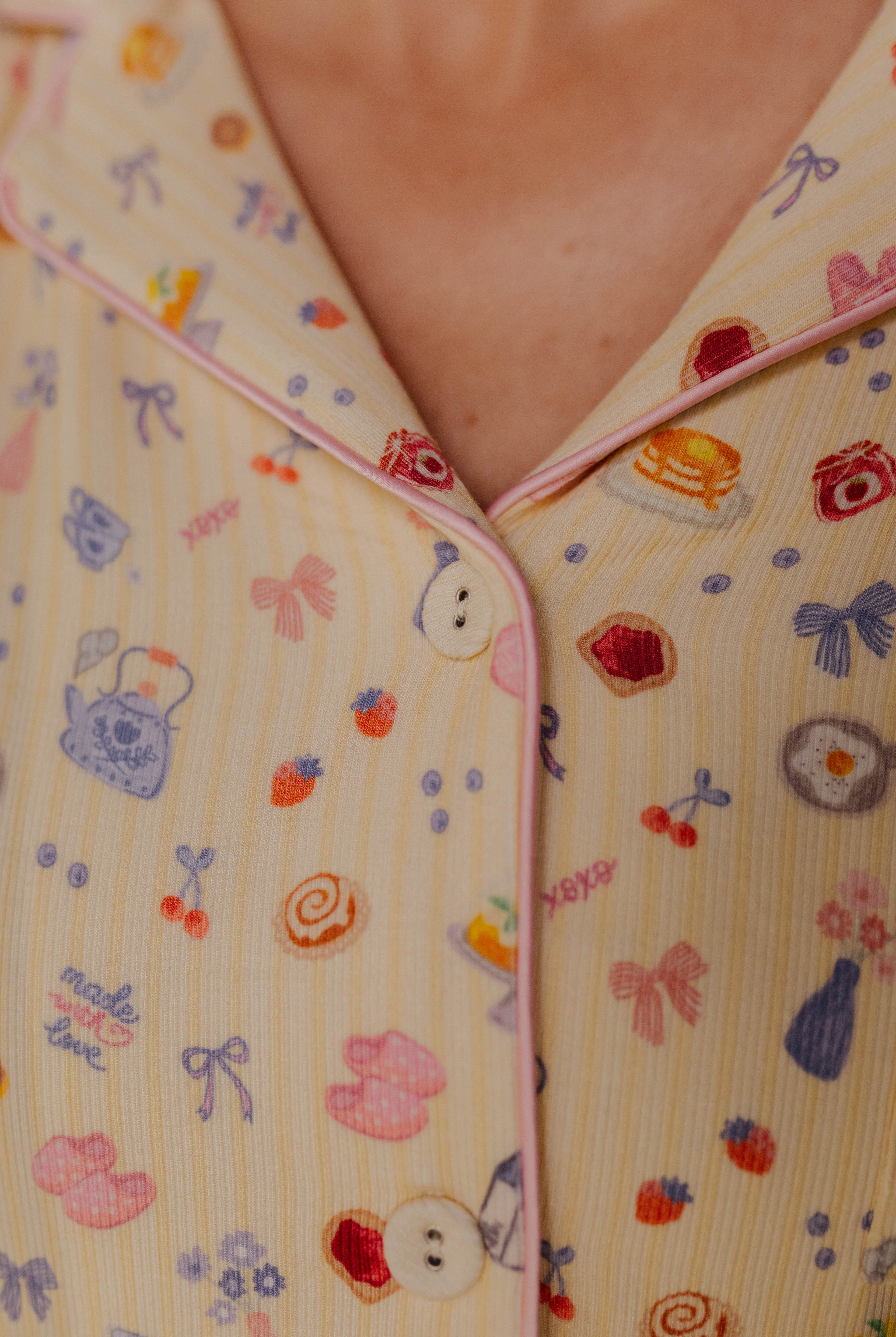 close up detail of pink piping, yellow buttons, and print
