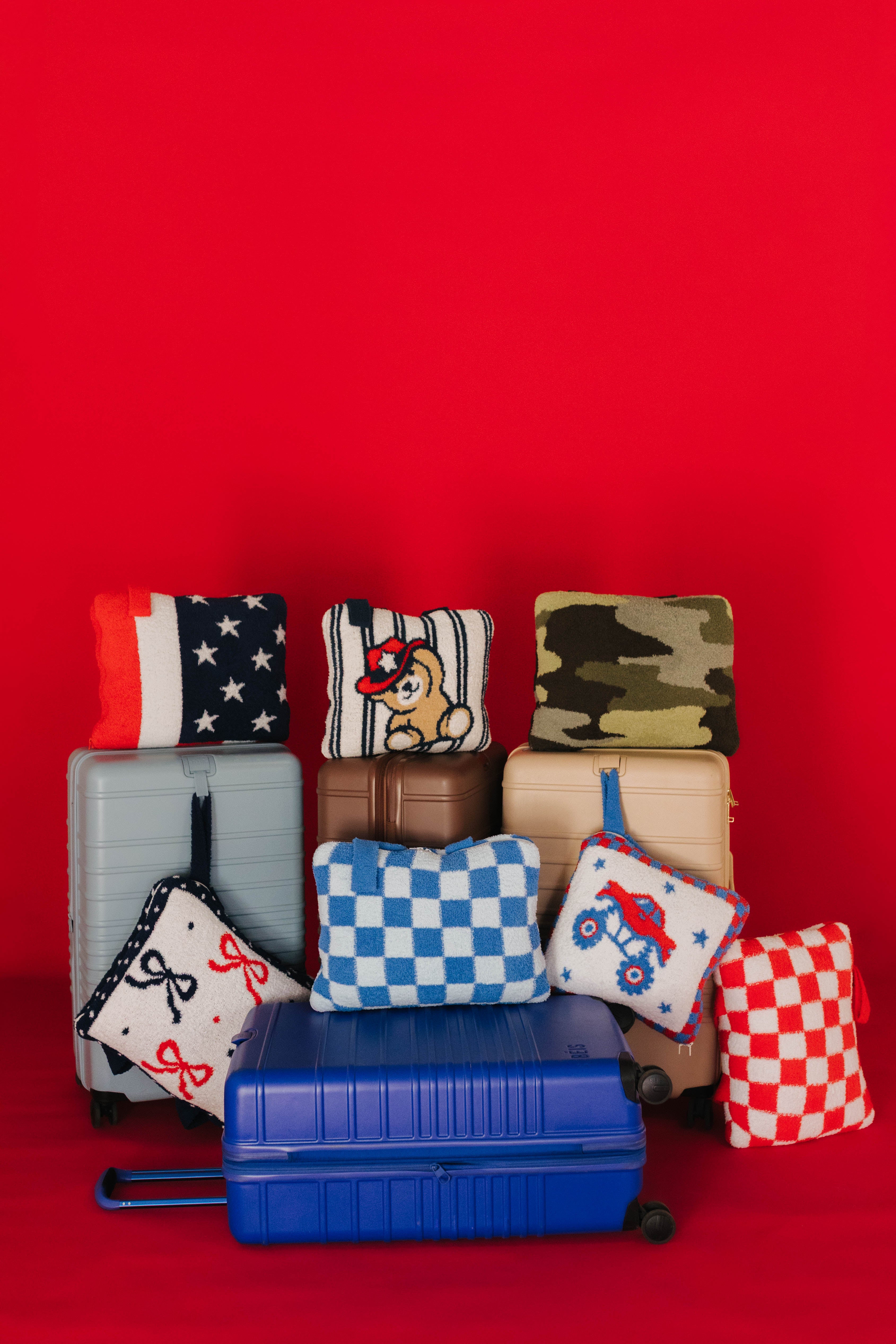 Collection of travel-related items including suitcases and quillows on a red background