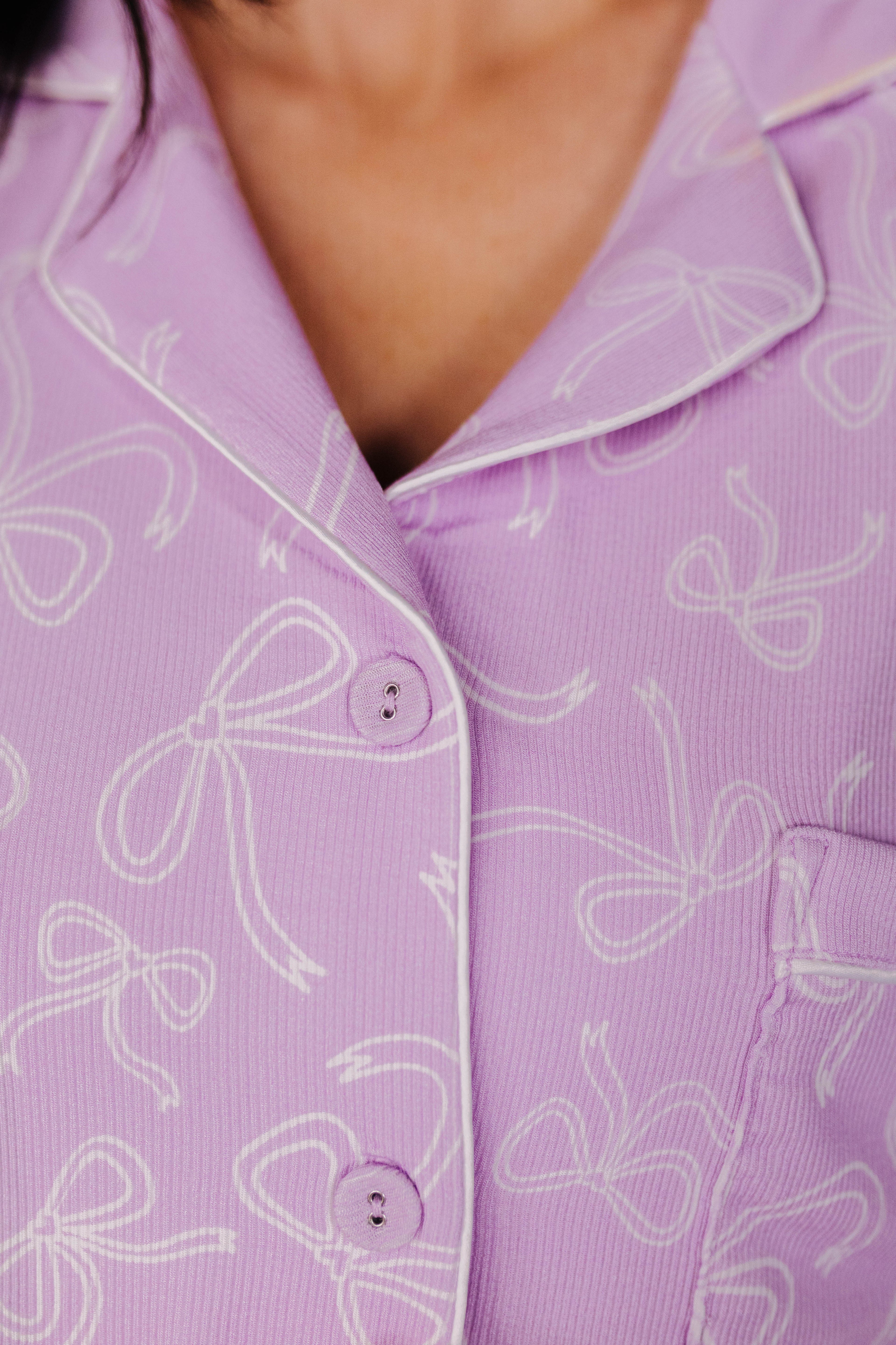 Close-up of a purple shirt with white bow patterns
