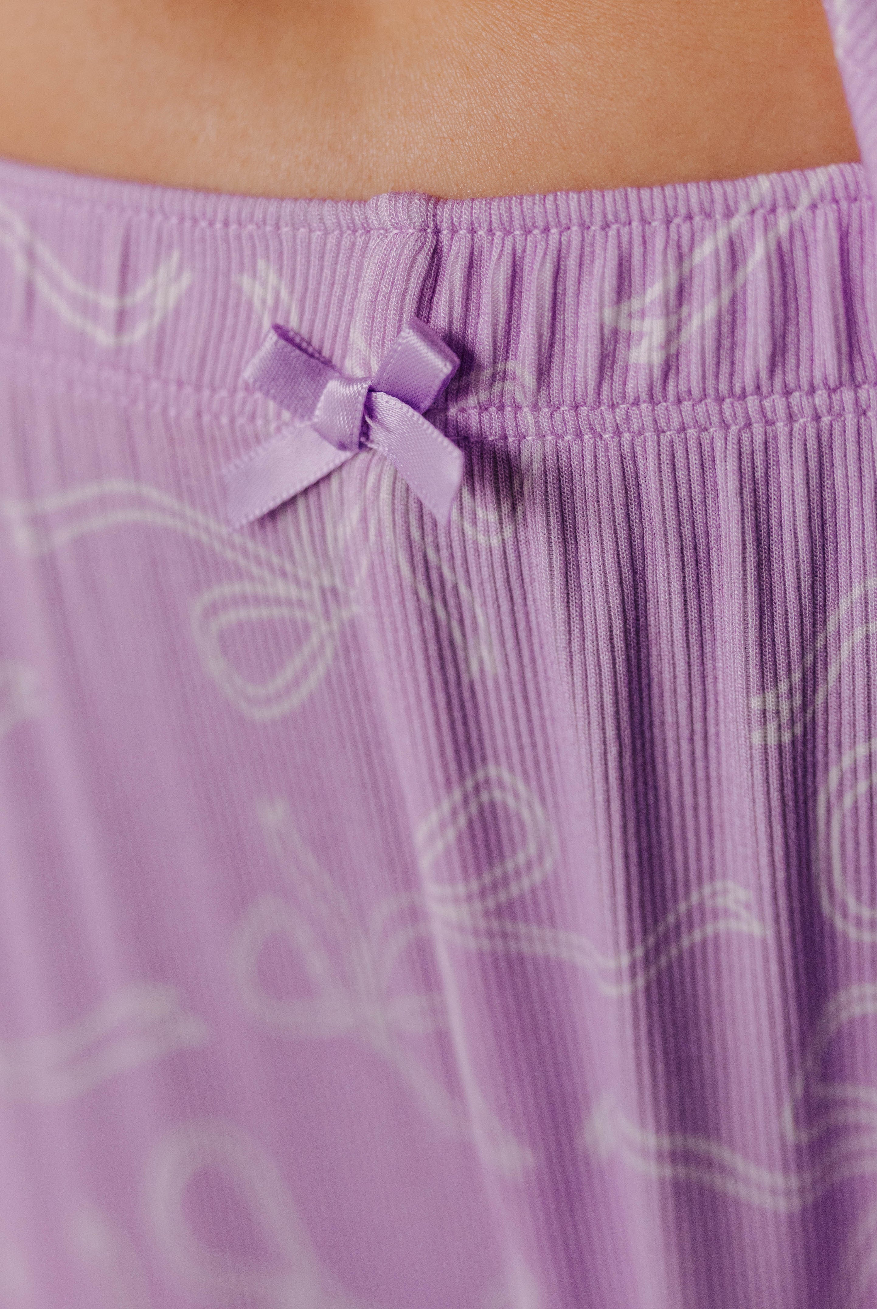 Close-up of a purple pants with a bow detail