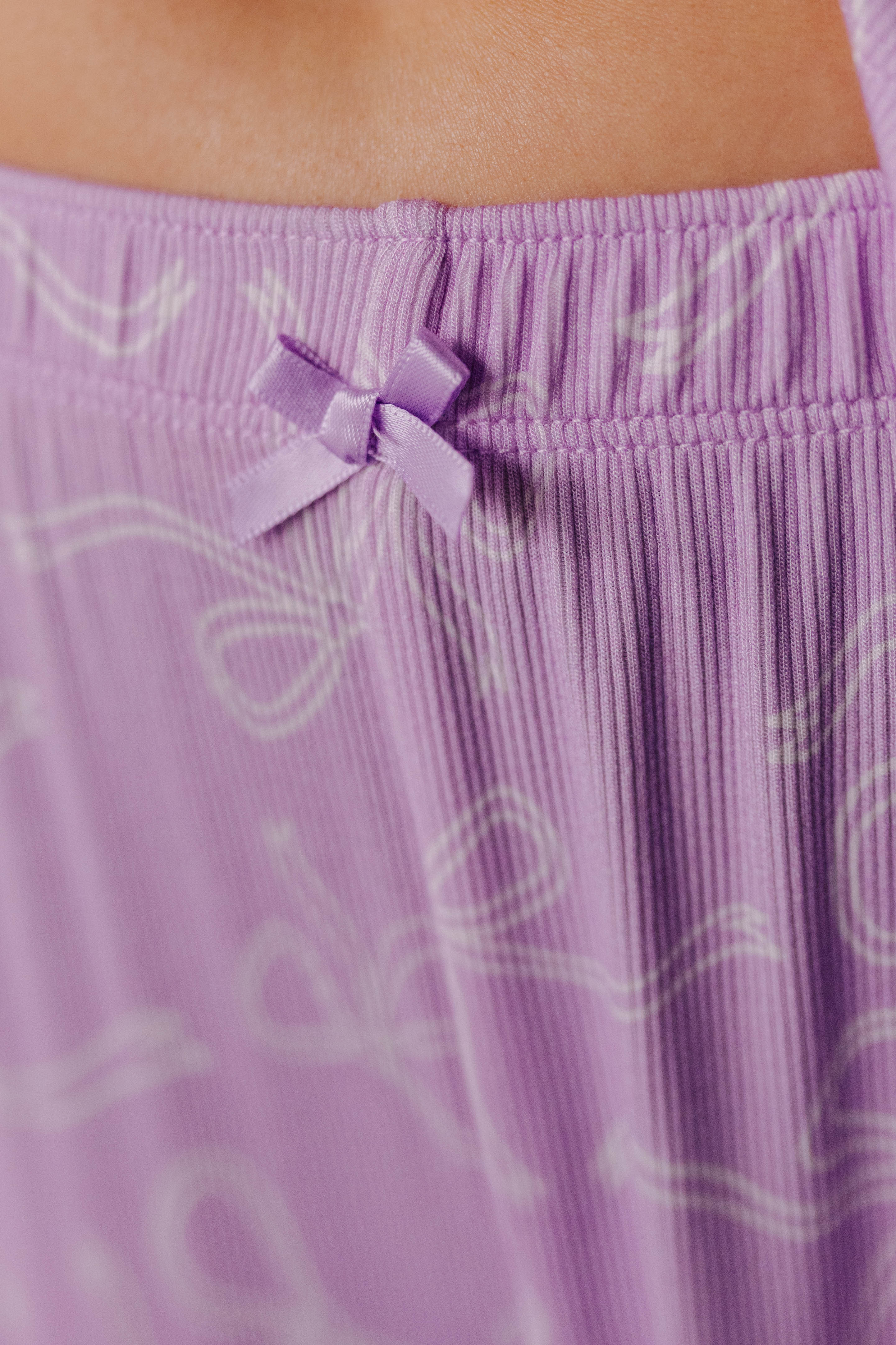 Close-up of a purple pants with a bow detail