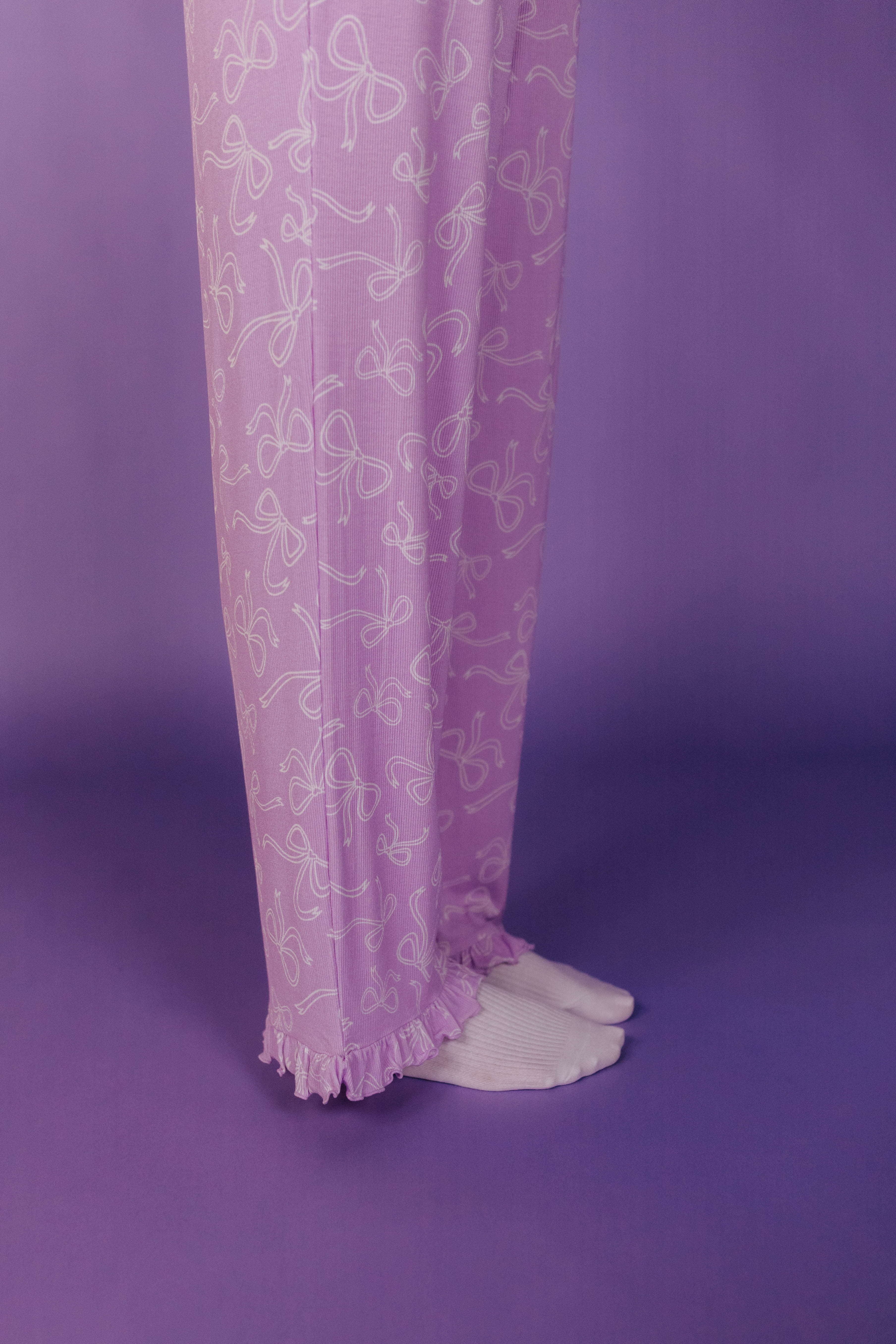Ruffle-trimmed pants on a purple background