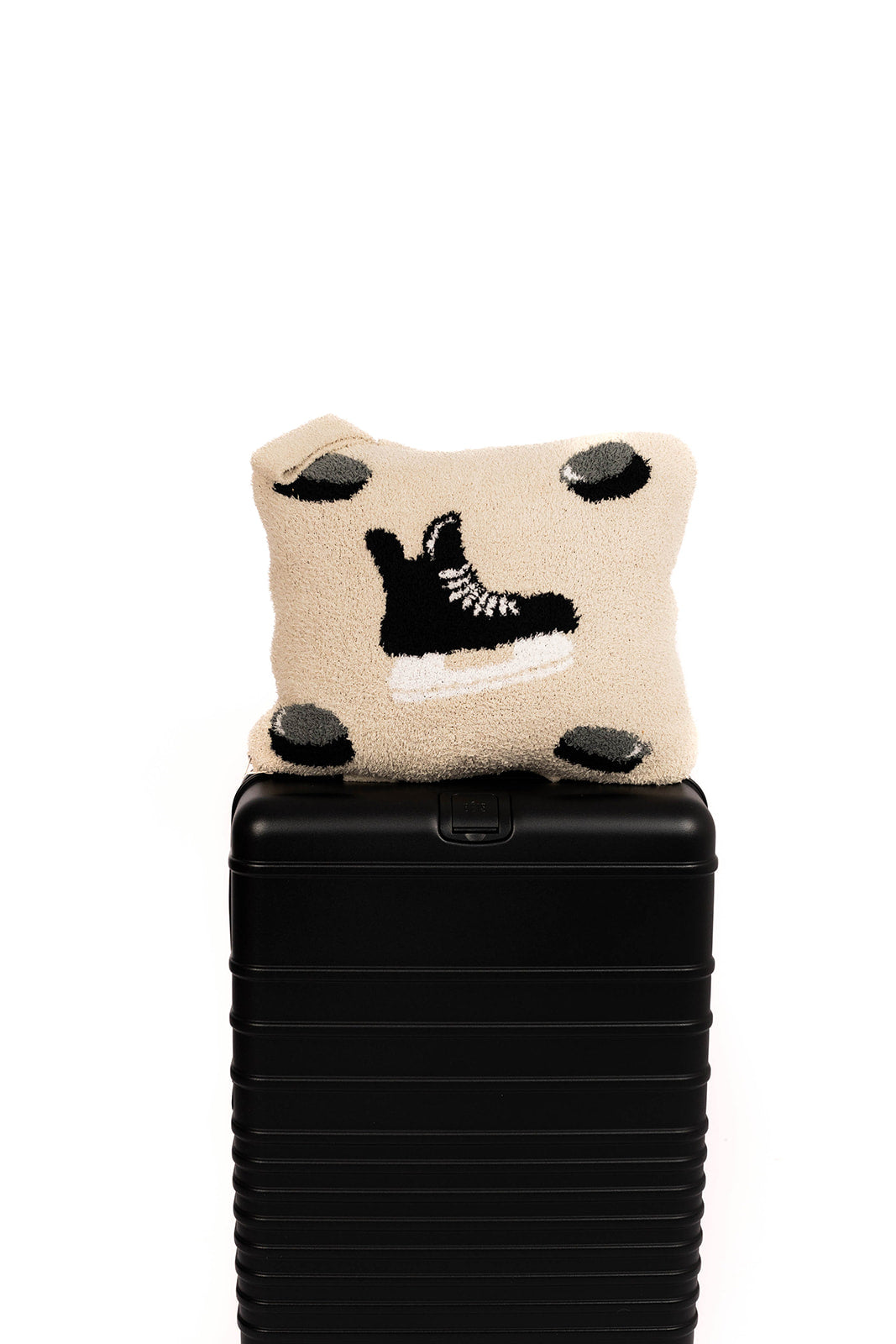 Quillow with a hockey design on top of a black suitcase against a white background
