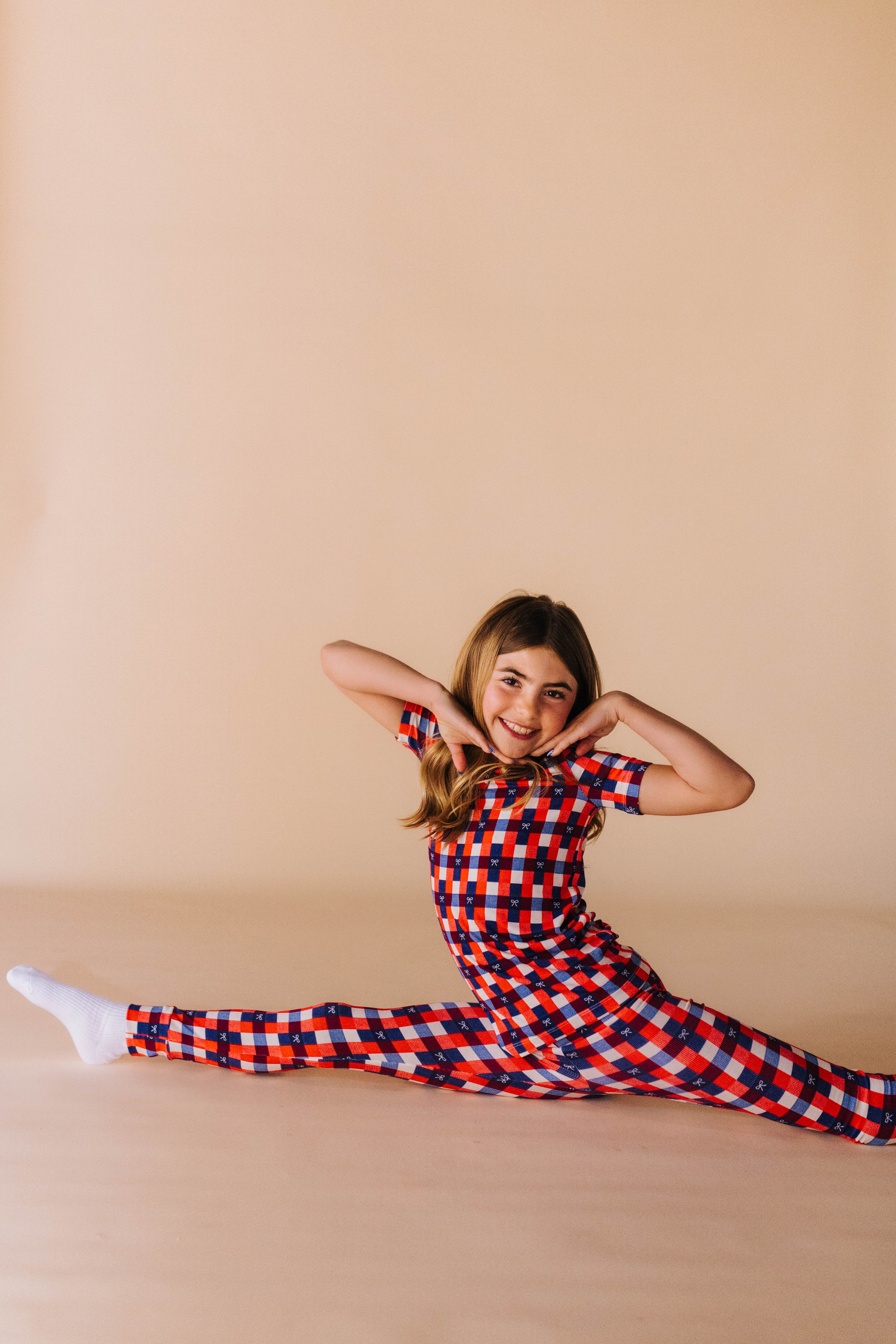 kolly doing the splits in her two piece gingham pj set