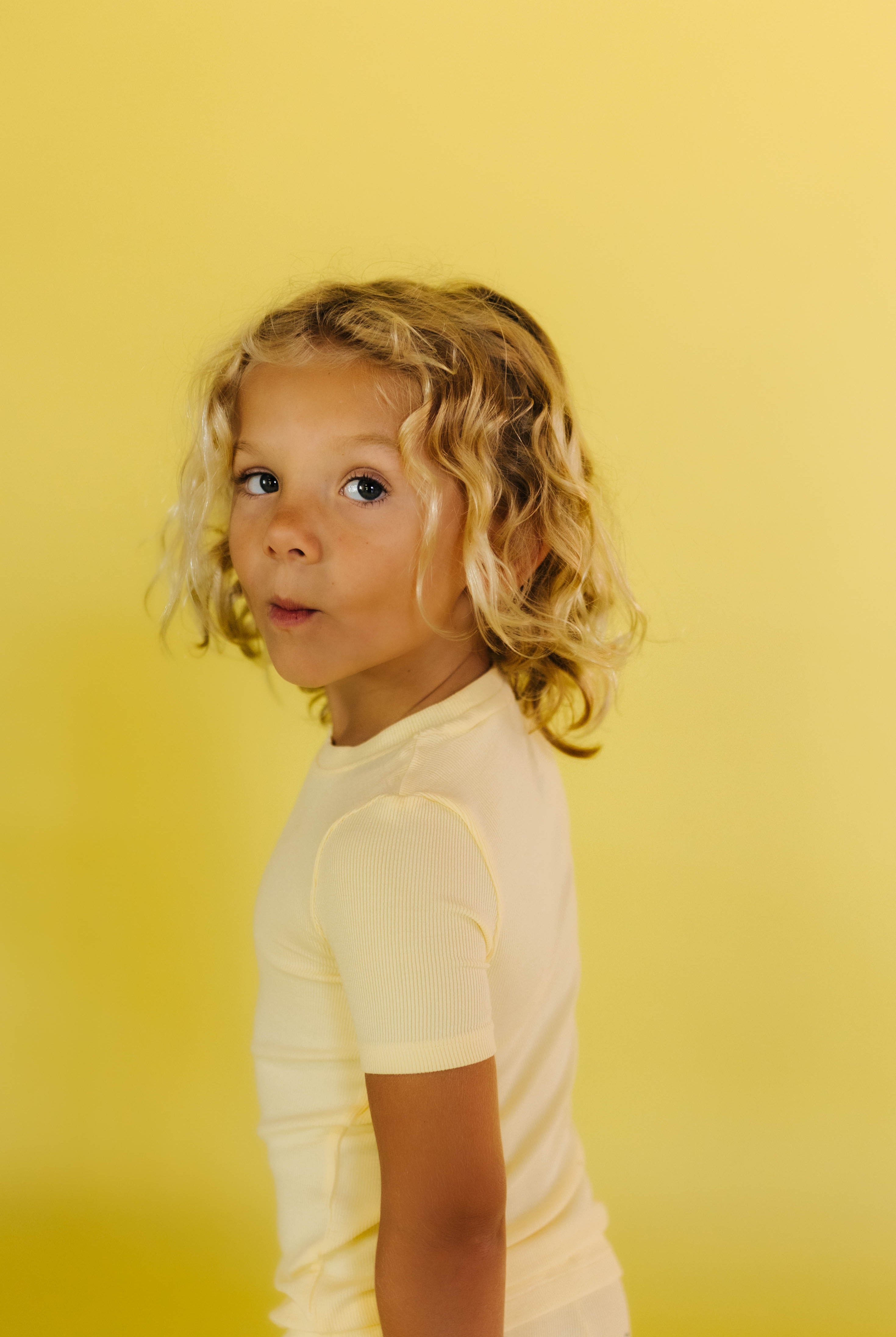 Kampers looking back at the camera in his yellow pjs and yellow background