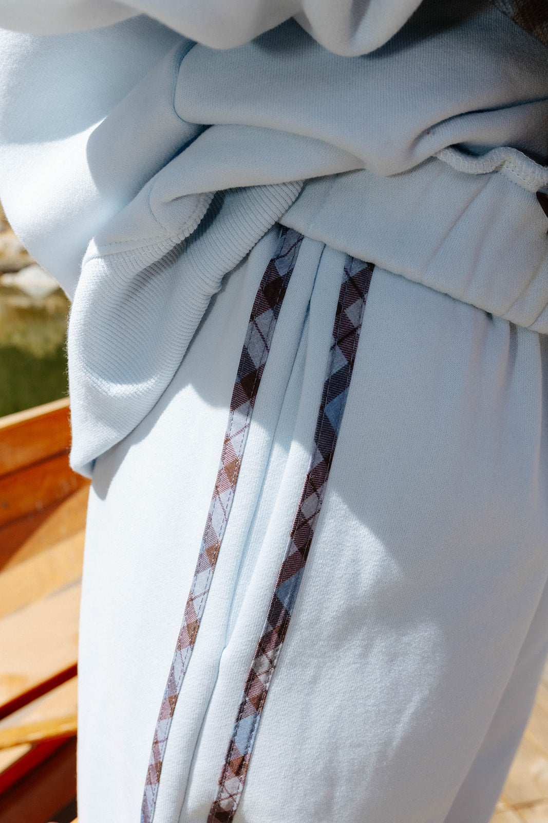 Detail of the side stripe on the light blue sweatpants.