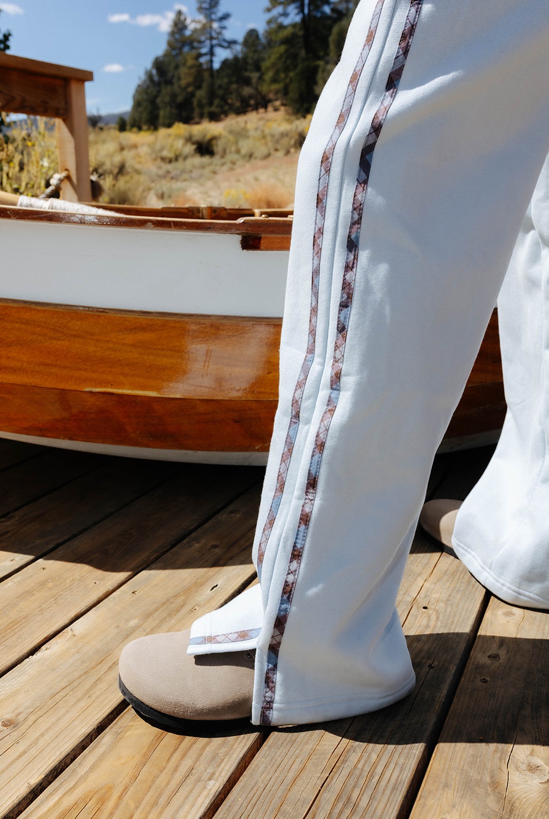 Full length side detail of the plaid stripe down the light blue sweatpants.