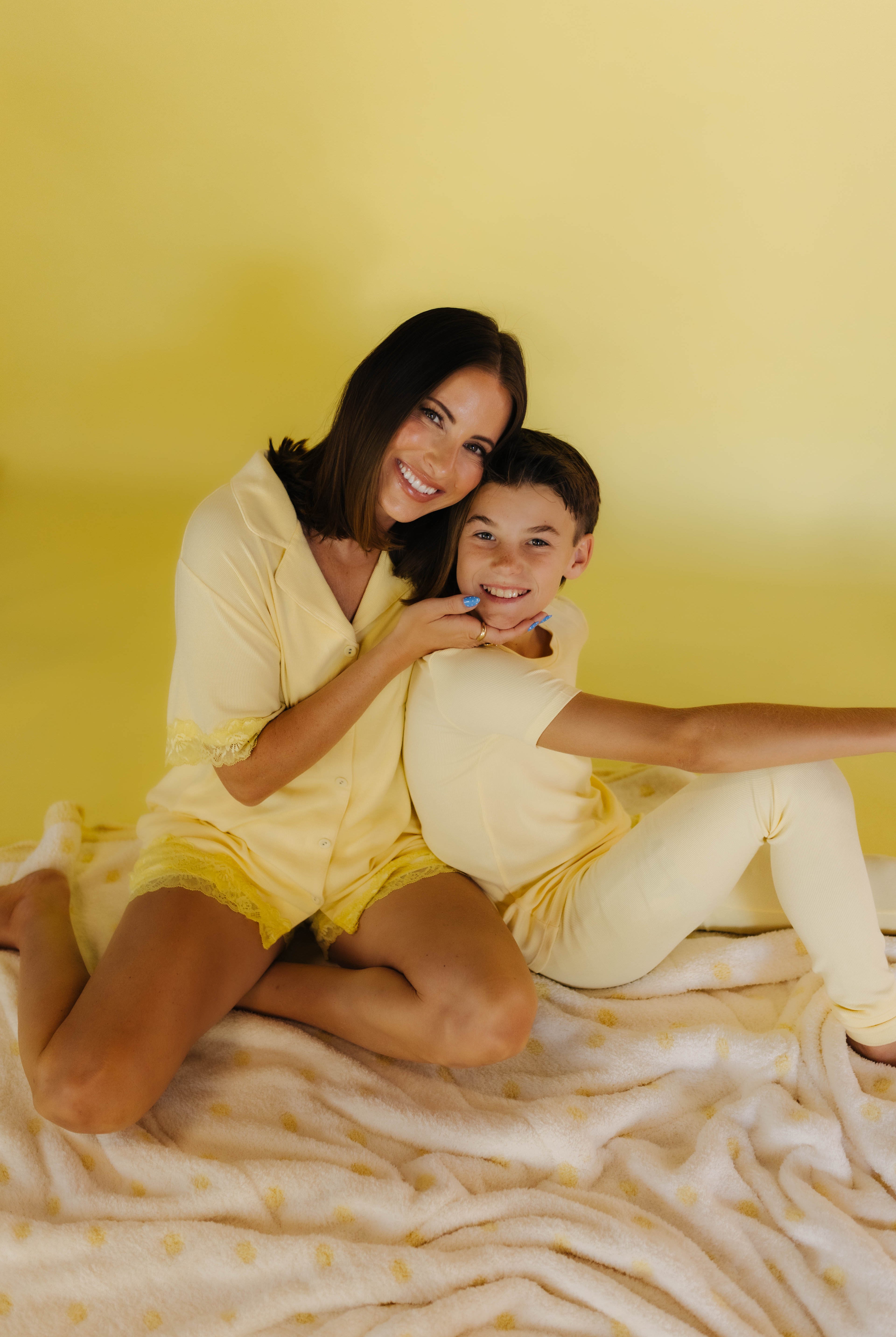 Boss and Krista smiling on the white and yellow polka quillow
