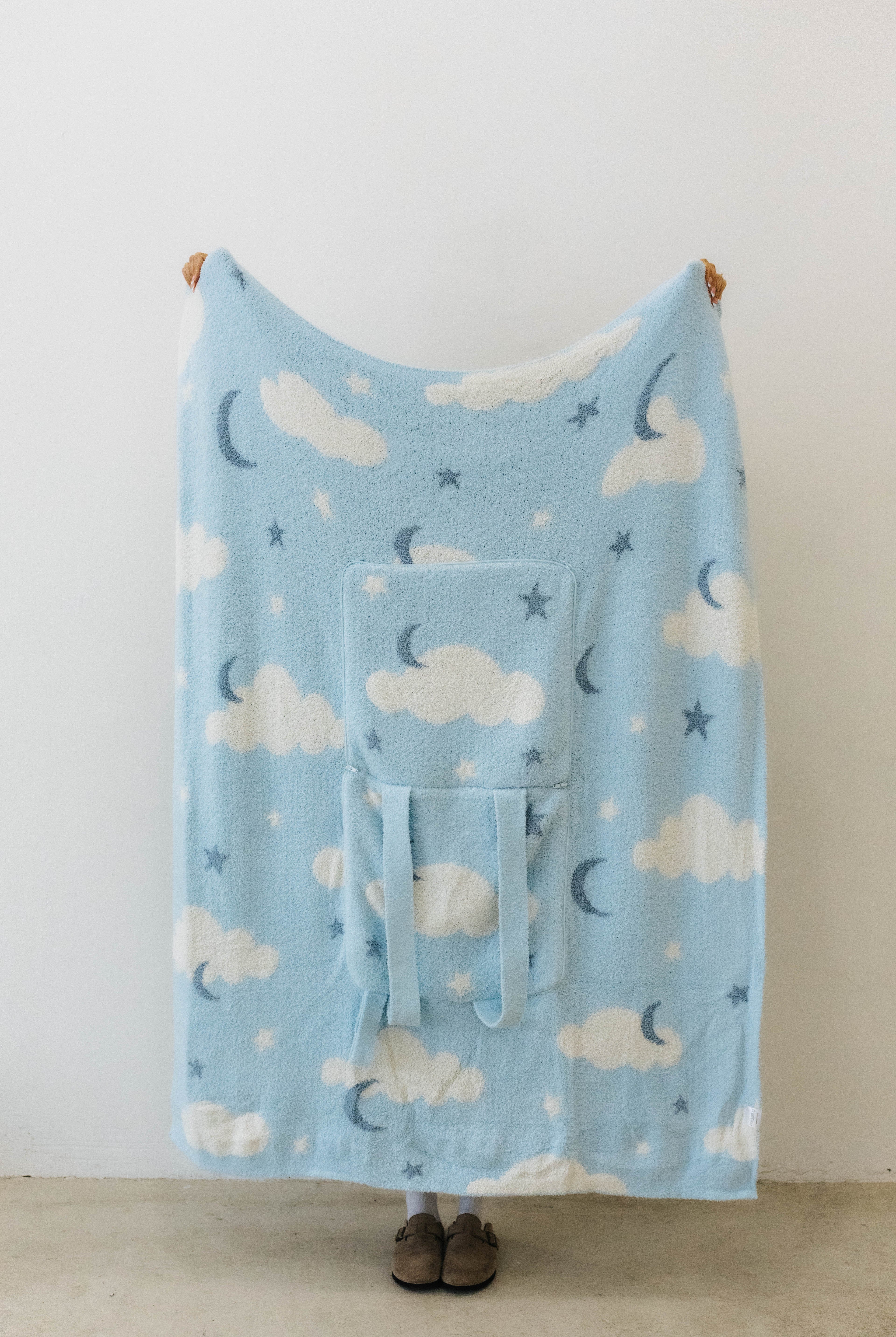 cloud backpack/wristlet quillow opened showing one side of the quillow showing moon, cloud, and star print