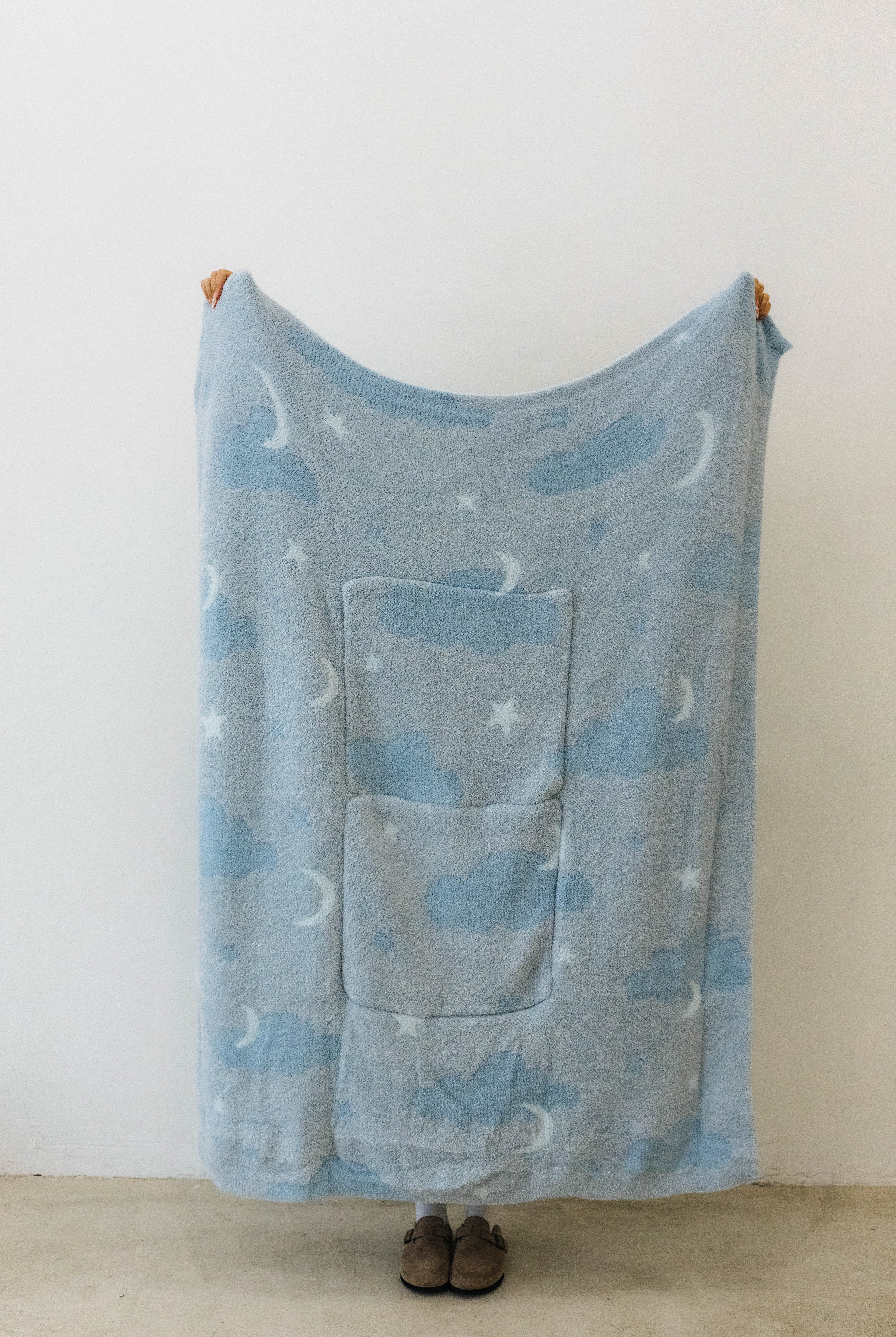 cloud backpack/wristlet quillow opened showing one side of the quillow showing moon, cloud, and star print