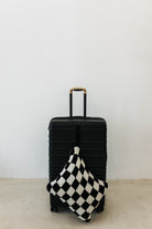 black check quillow hanging from black suitcase