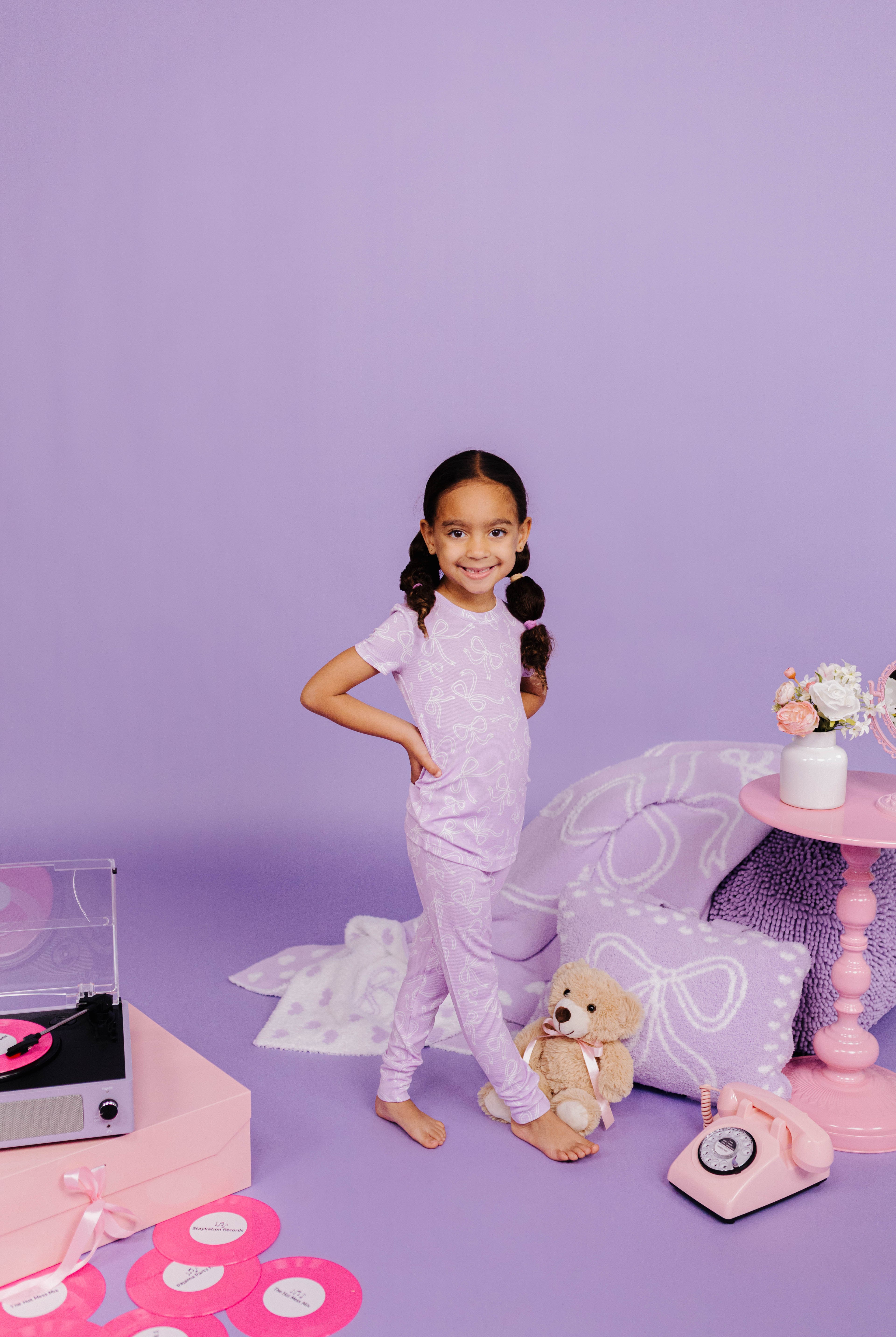 Young girl on purple background with toys and decor