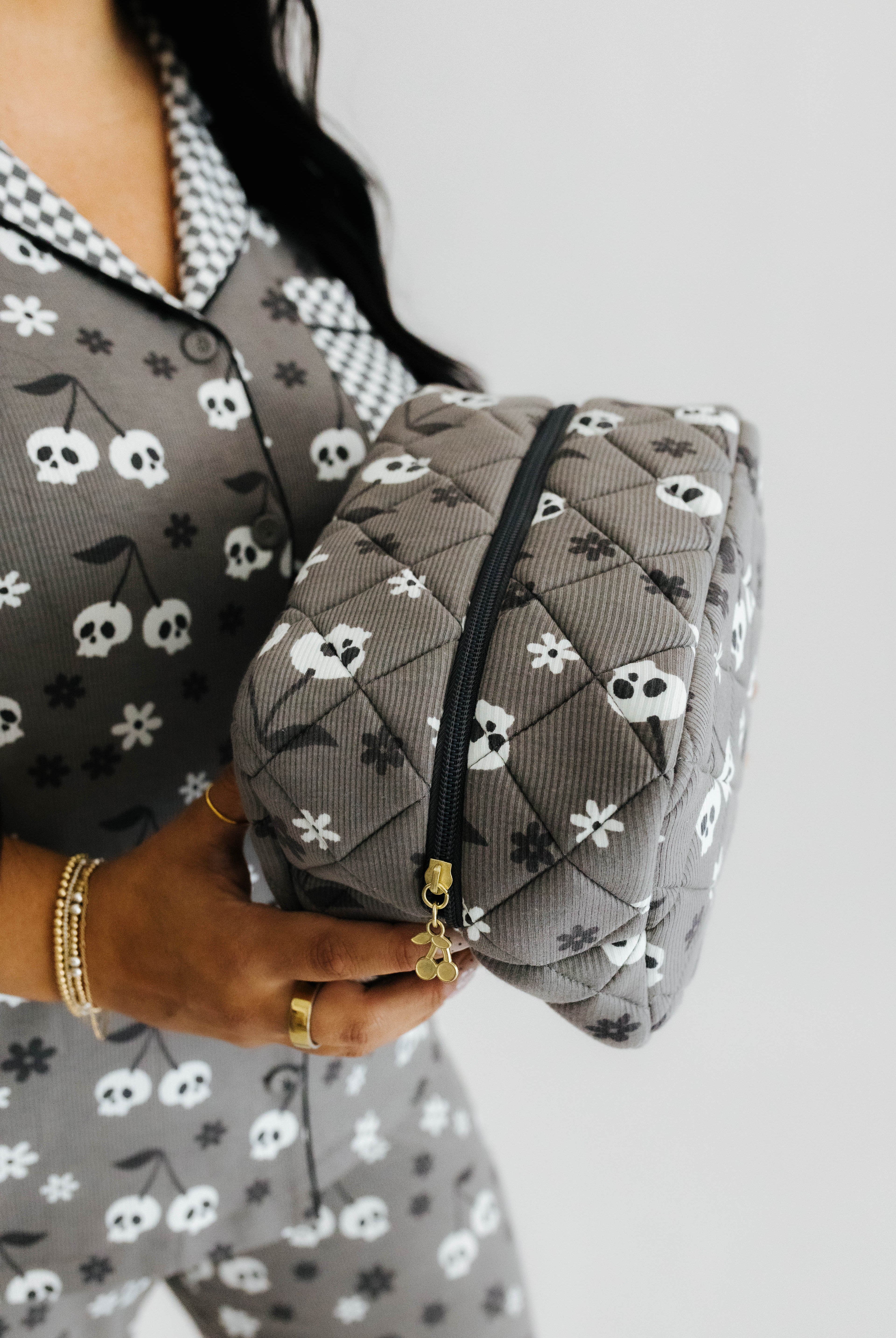 model holding skelly cosmetic bag