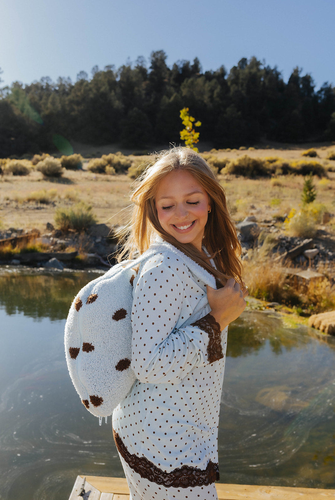 Model carrying the light blue and brown polka dot quillow as a backpack.