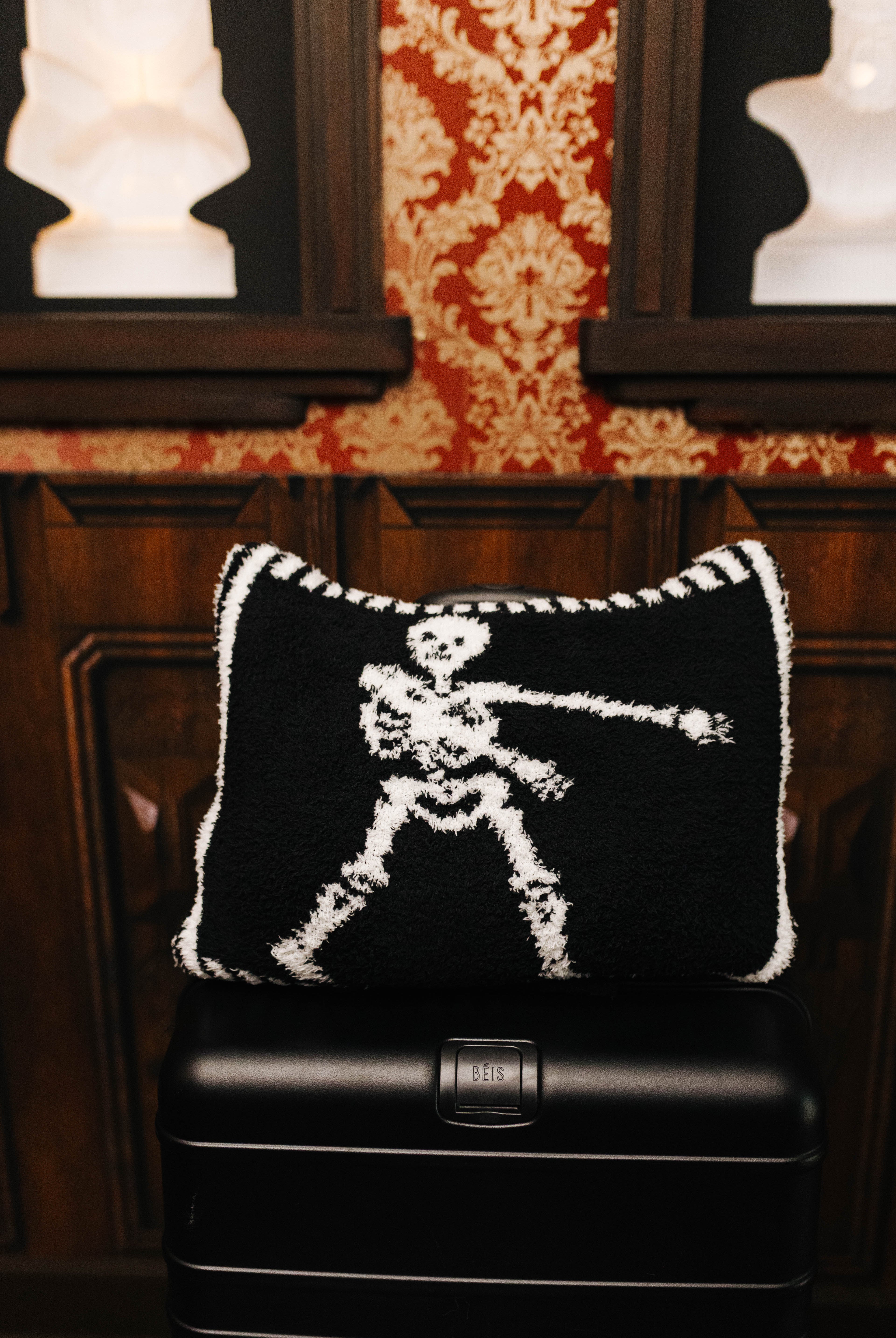 Skelly quillow folded into a pillow on a suitcase
