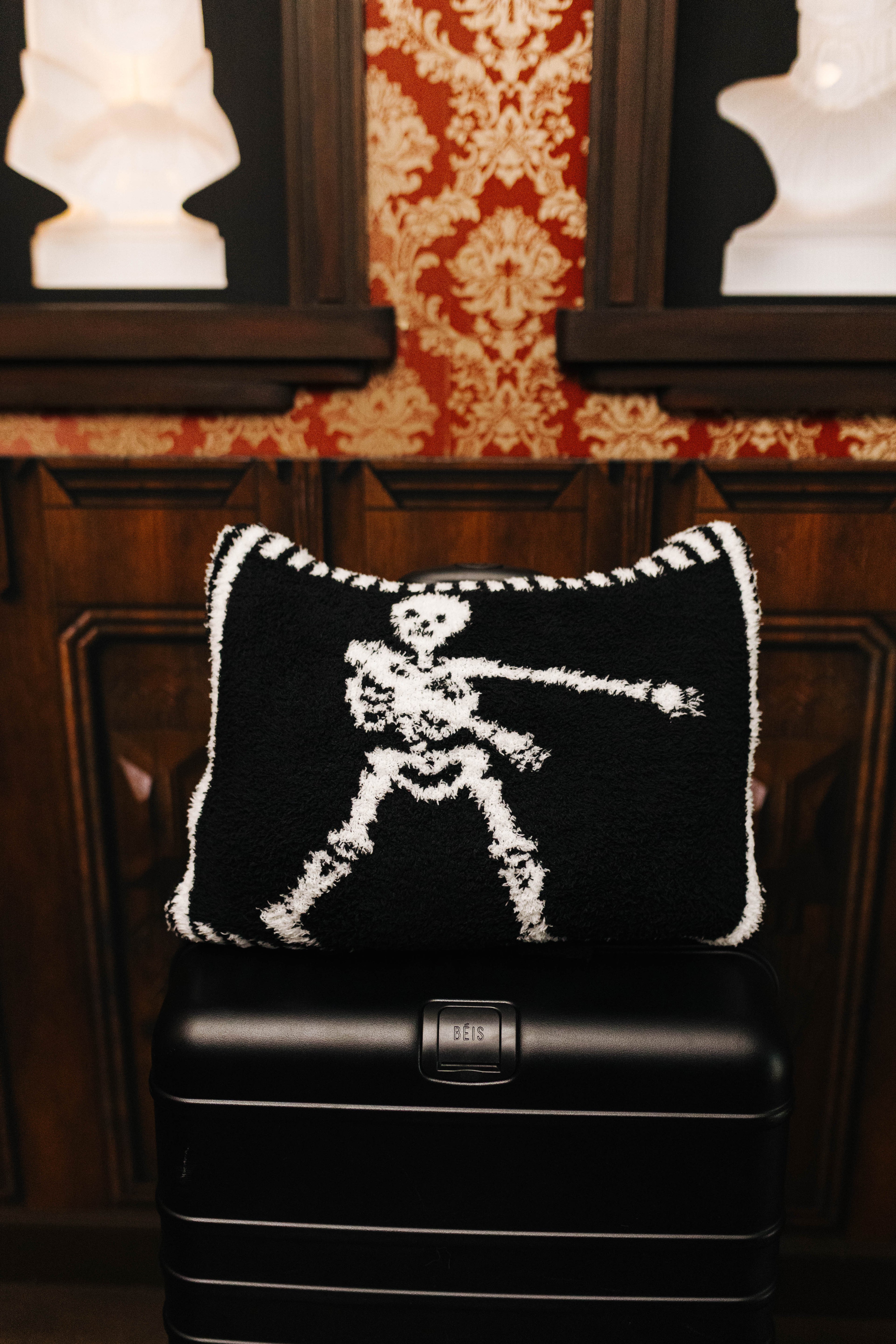Skelly quillow folded into a pillow on a suitcase