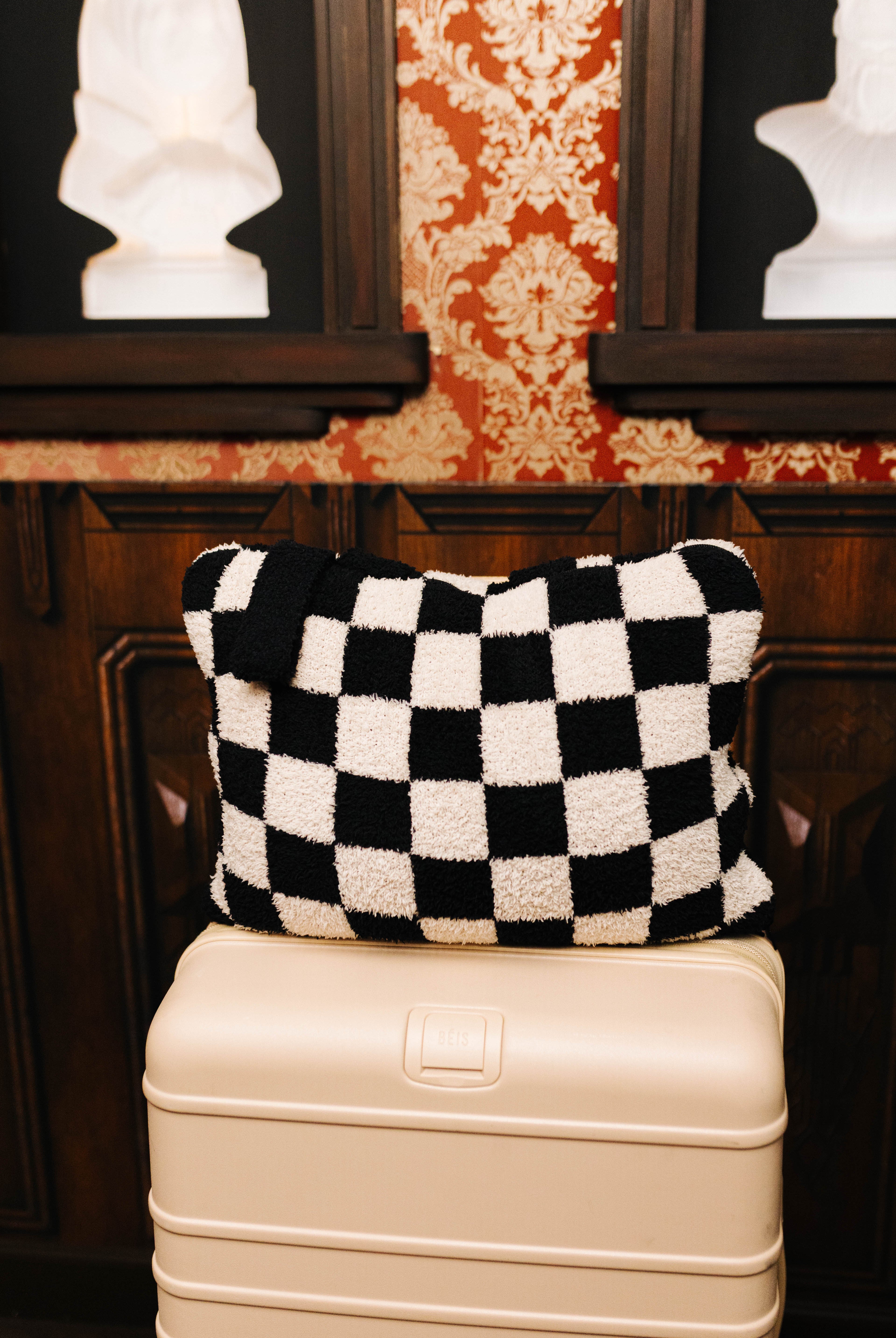 Sand and black check quillow folded on a suitcase