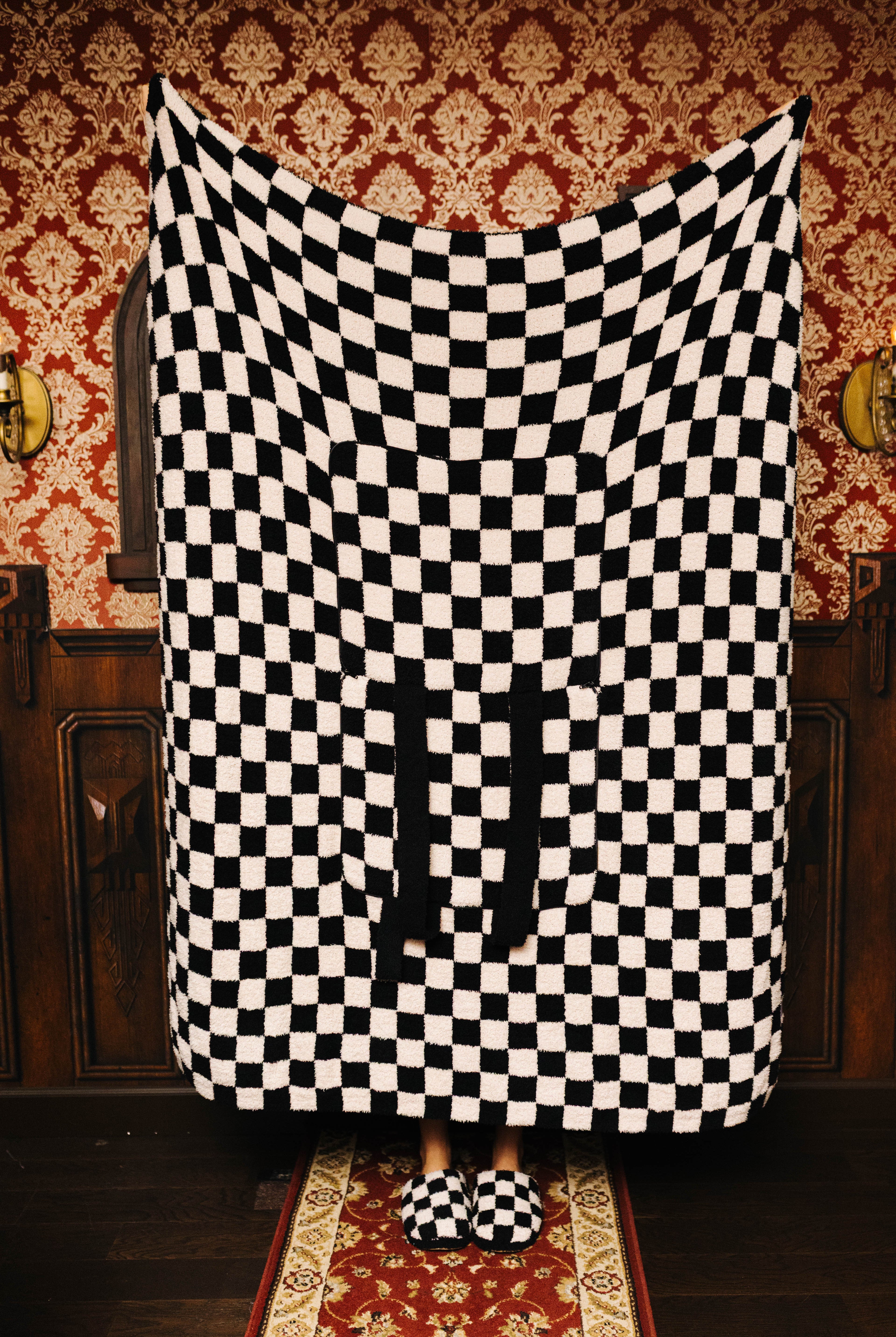 Sand and black check quillow unfolded as a blanket
