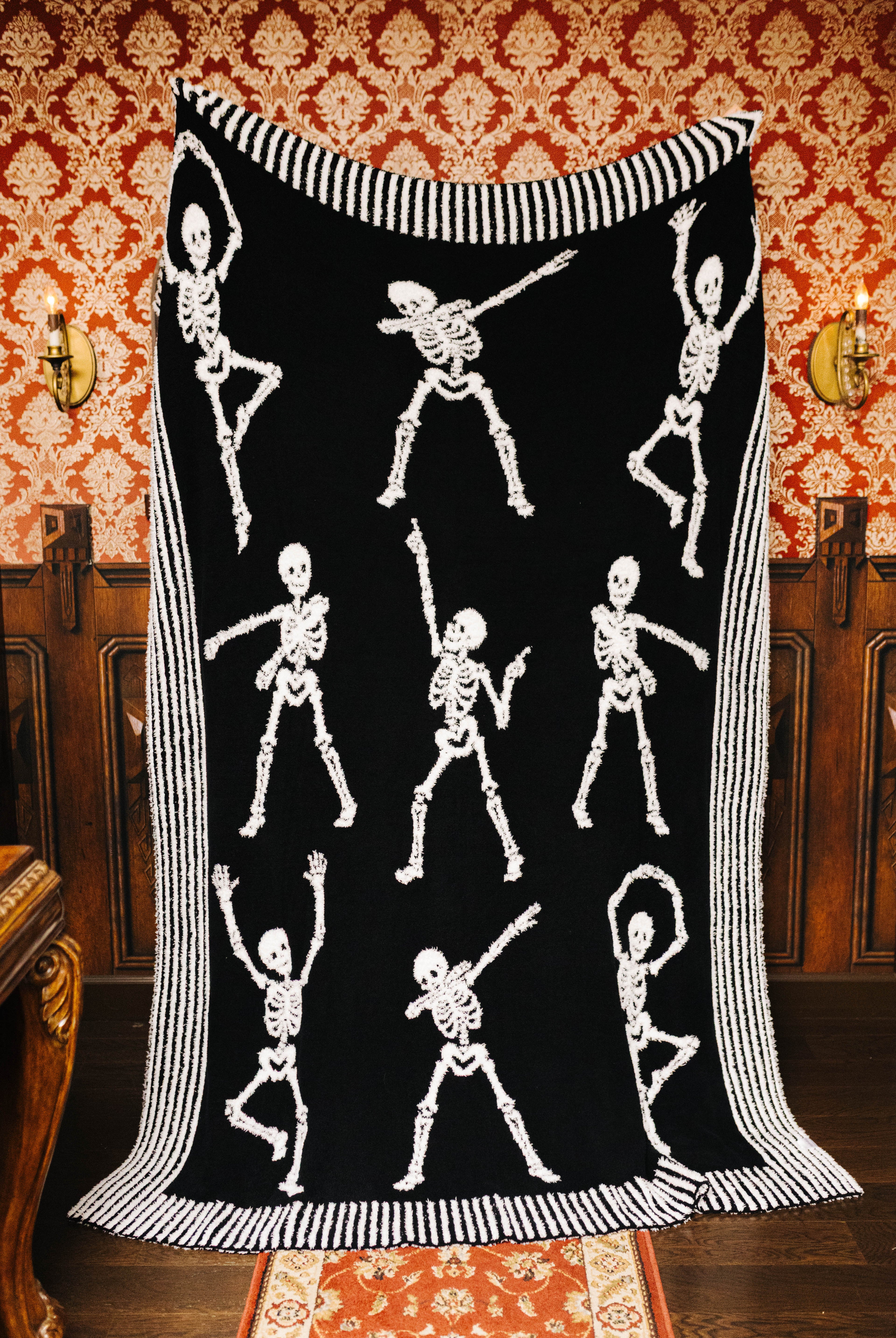 Skelly blanket held open to show the black skeleton side