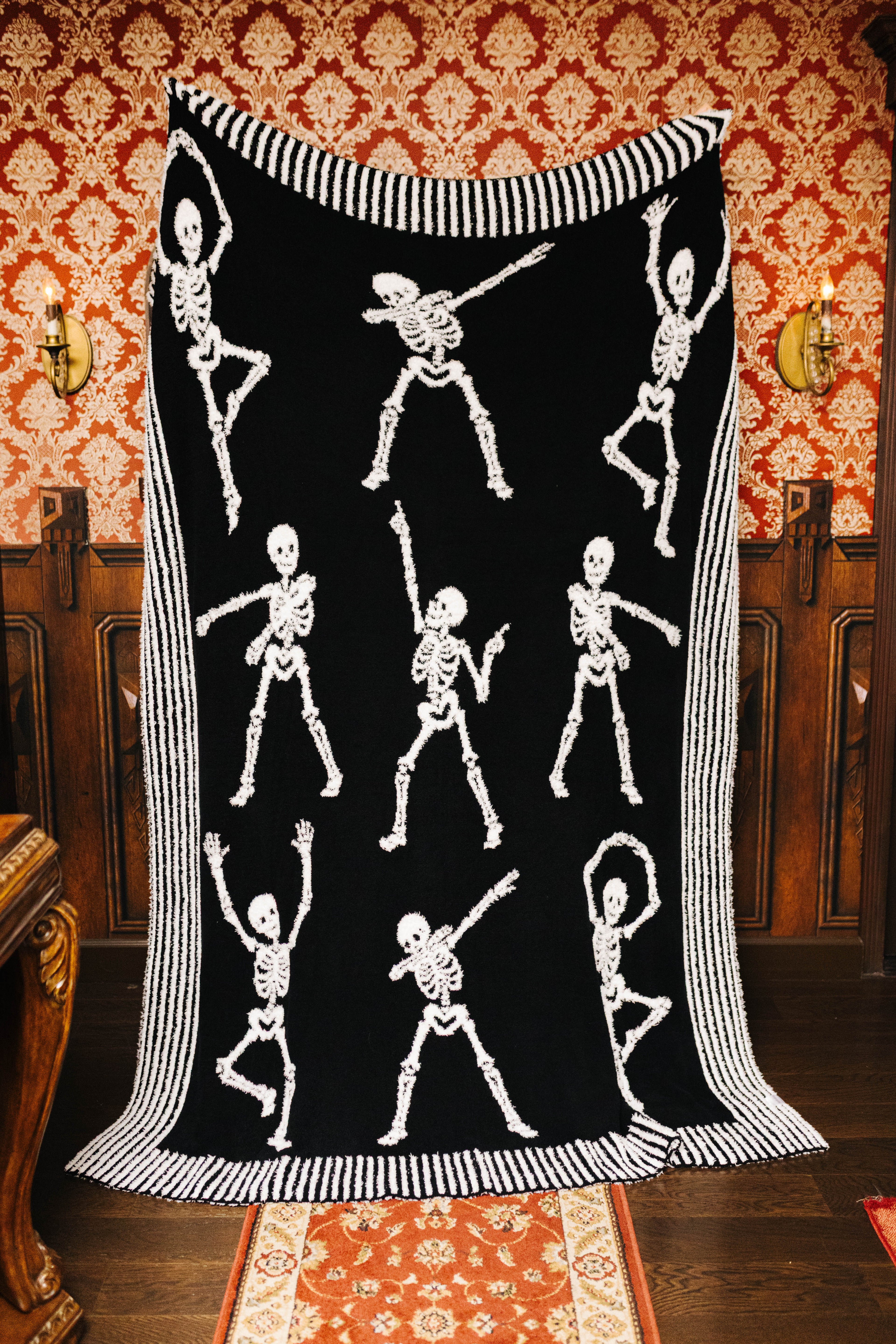 Skelly blanket held open to show the black skeleton side