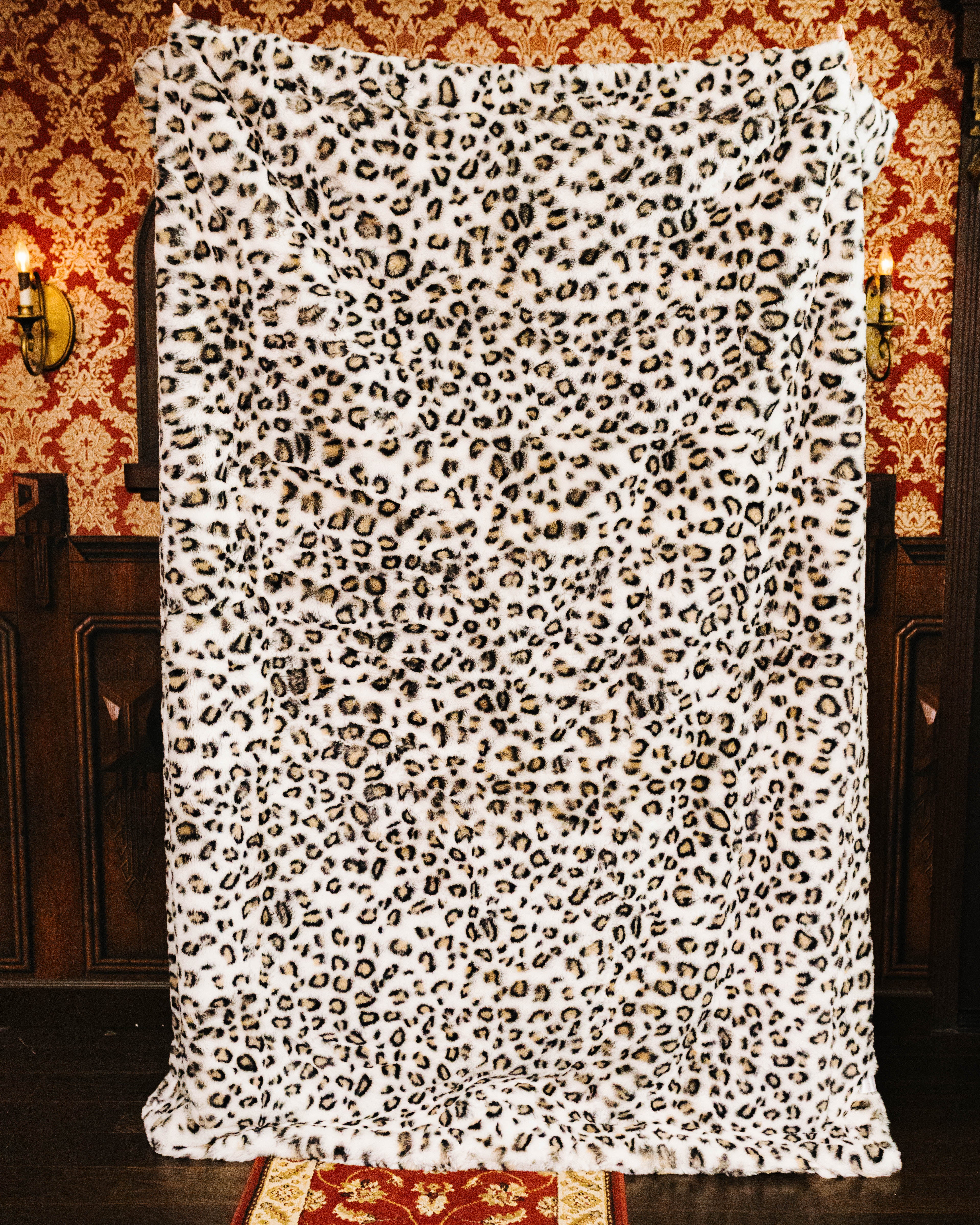 Leopard faux fur blanket held open to show the full print