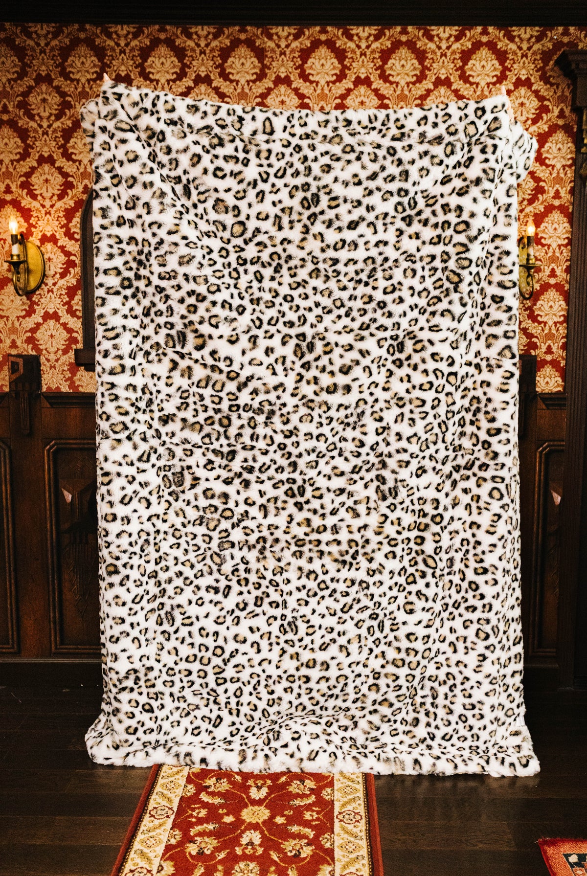 Leopard faux fur blanket held open to show the full print