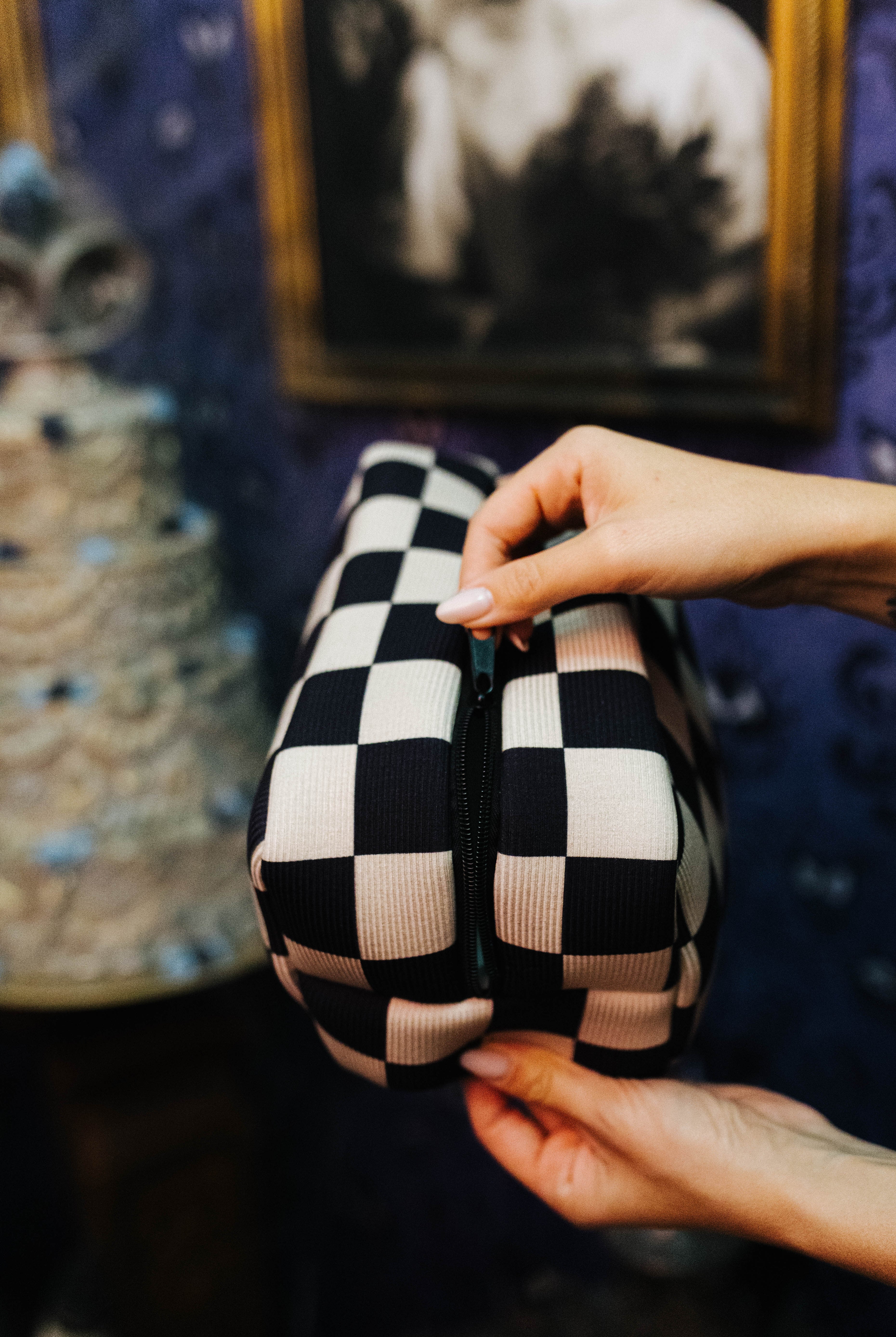 Sand and black check cosmetic bag showing its zipper