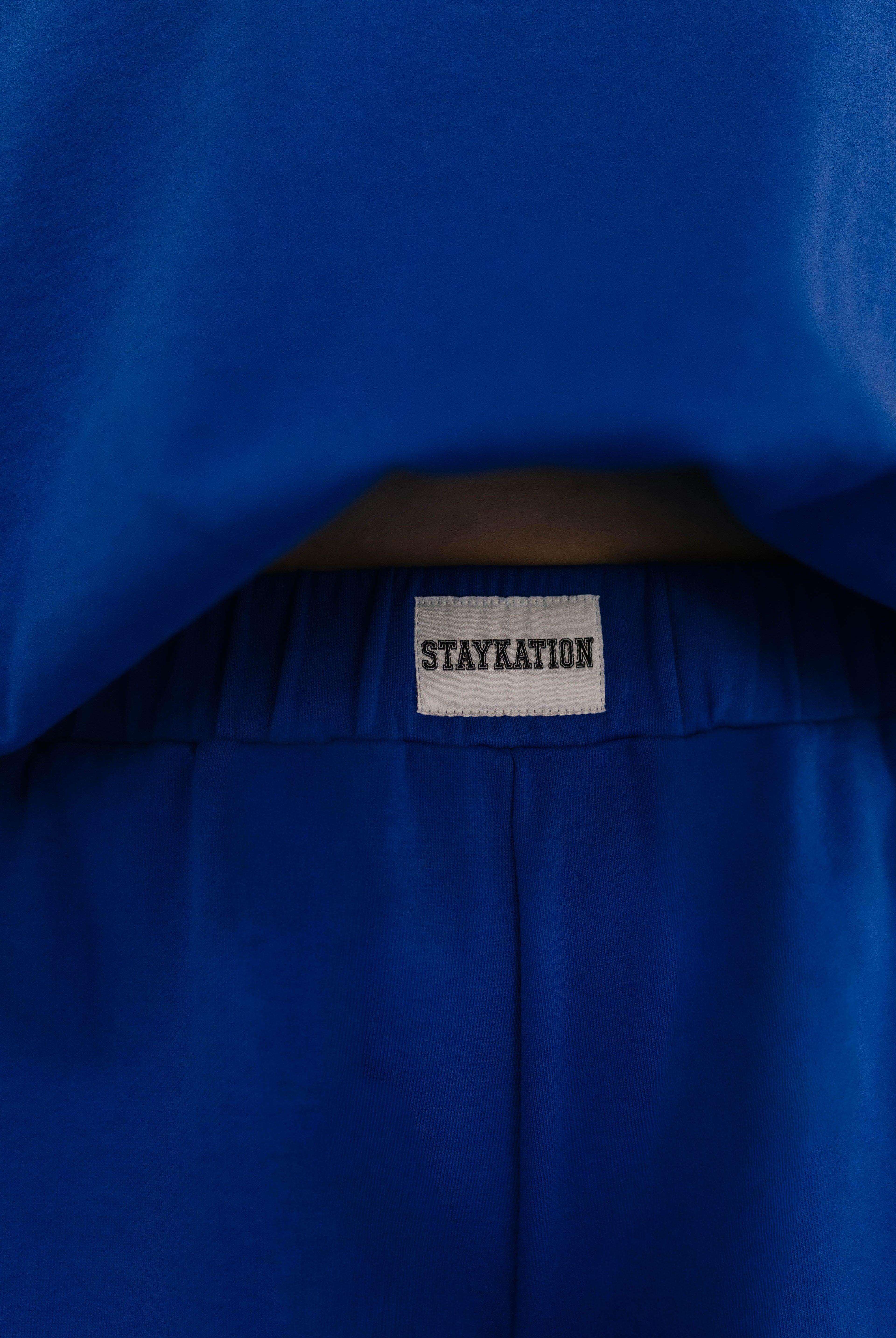 Showing the Staykation logo on the front of the shorts