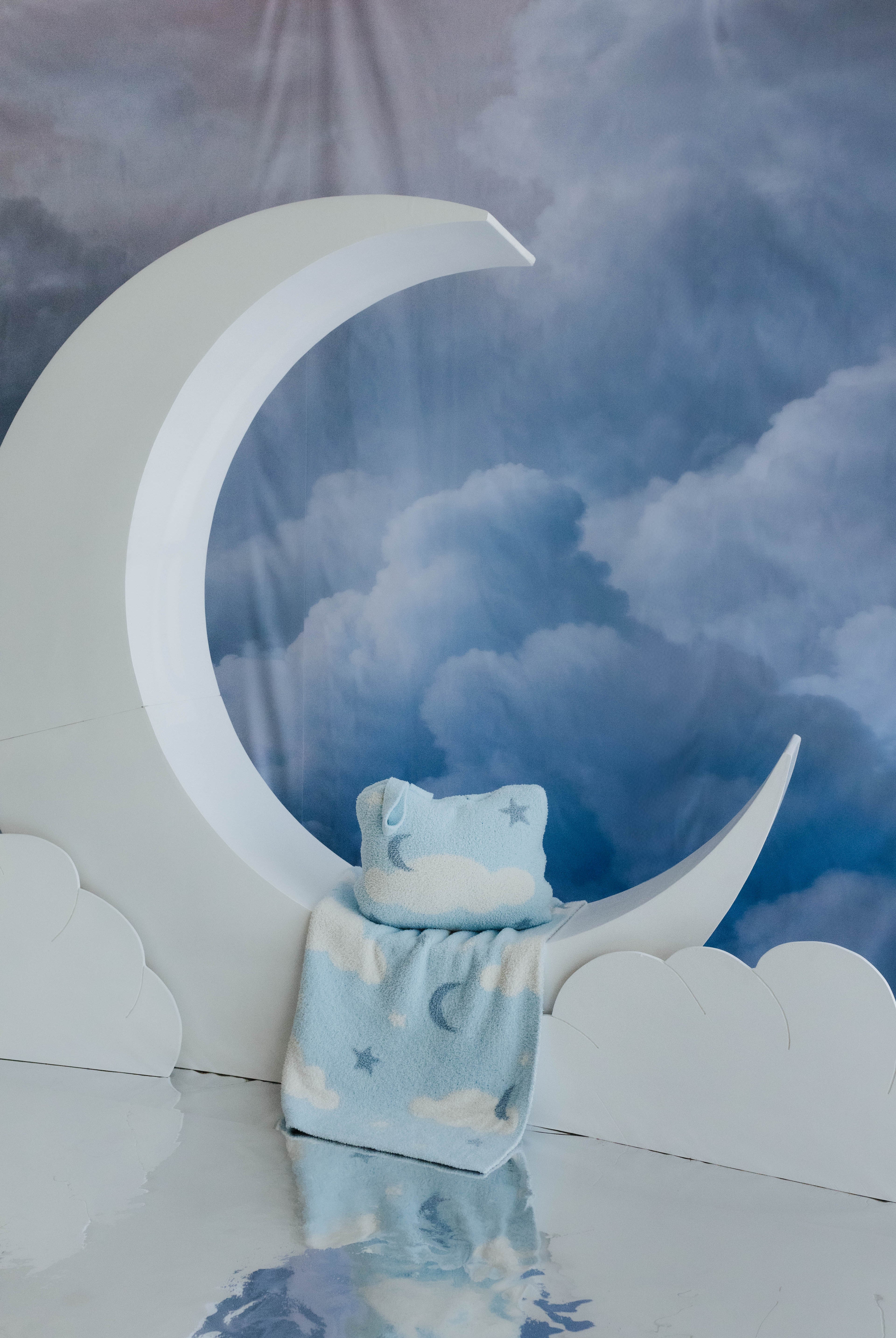 cloud backpack/wristlet quillow and cloud baby blanket sitting on moon decorations