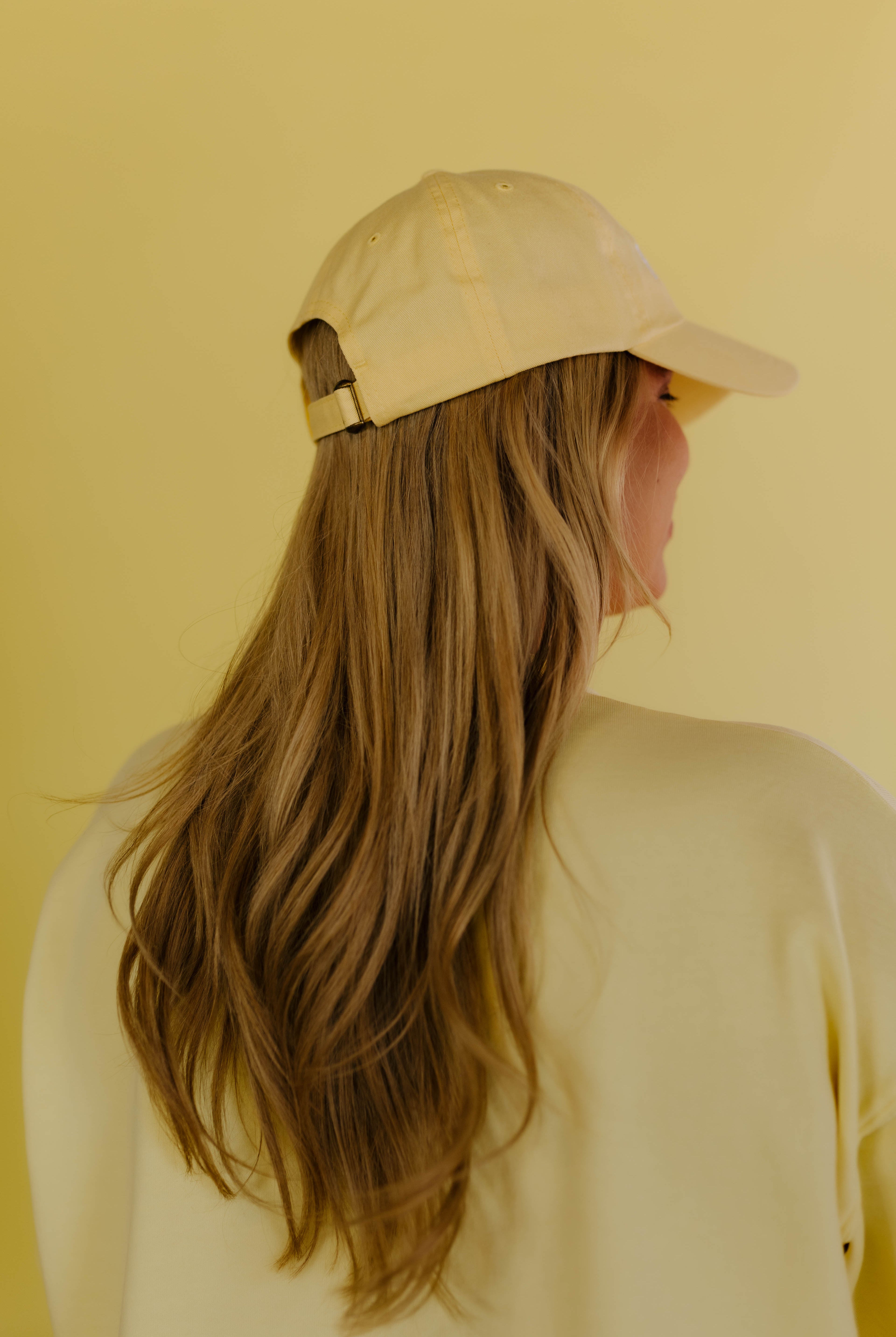 Person wearing a yellow hat against a yellow background