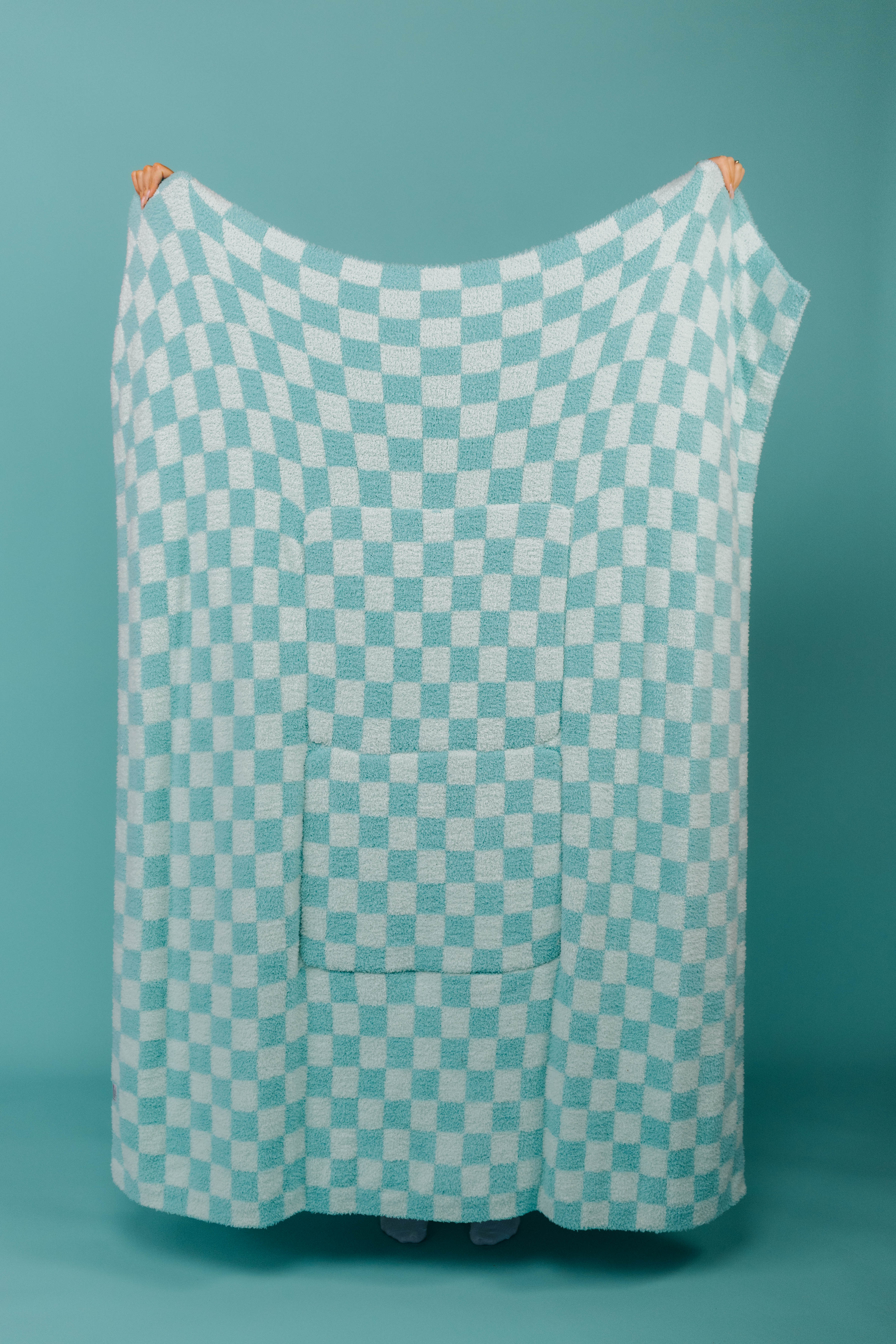 holding the teal check quillow showing the back