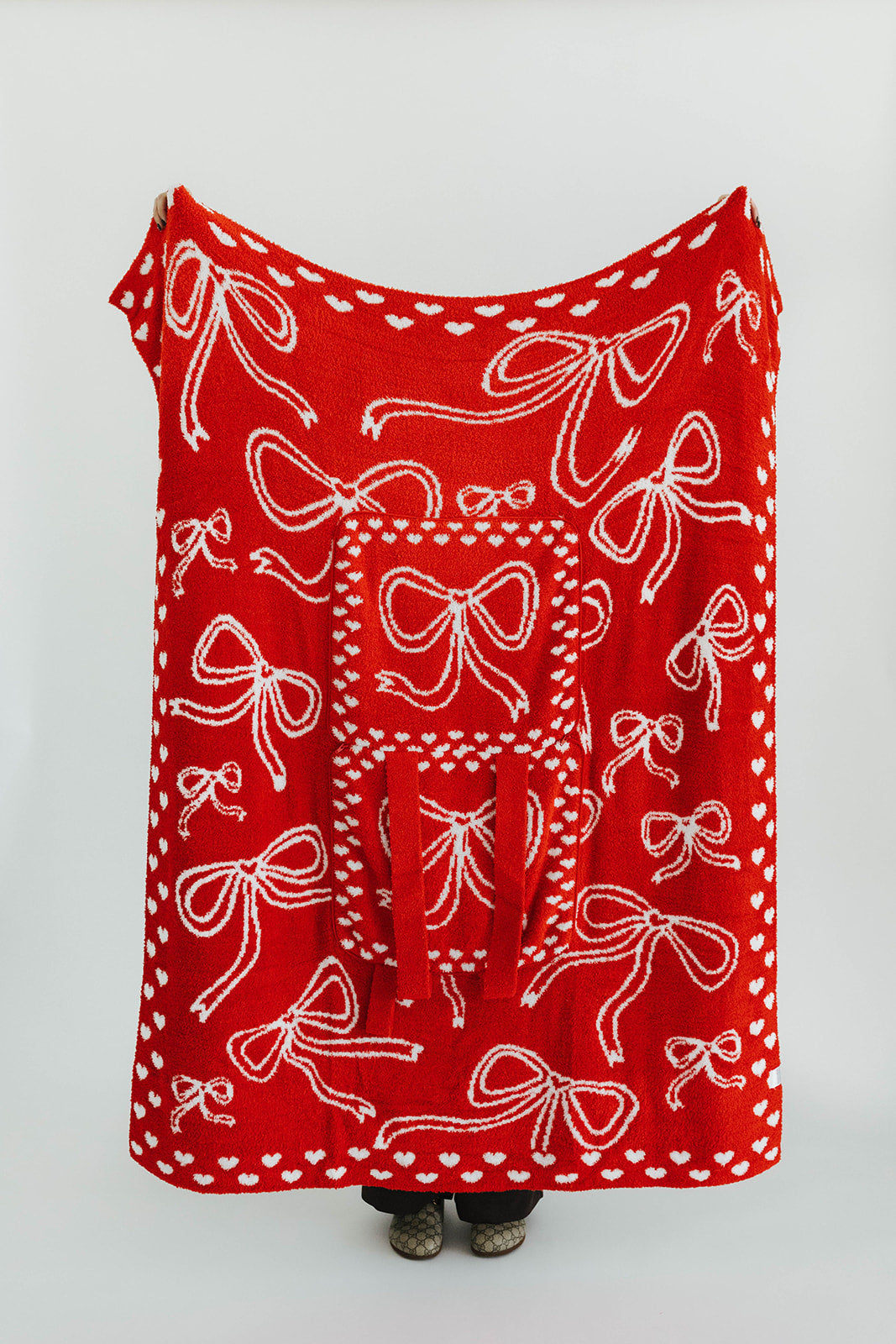 Red blanket with white bow pattern on a plain background