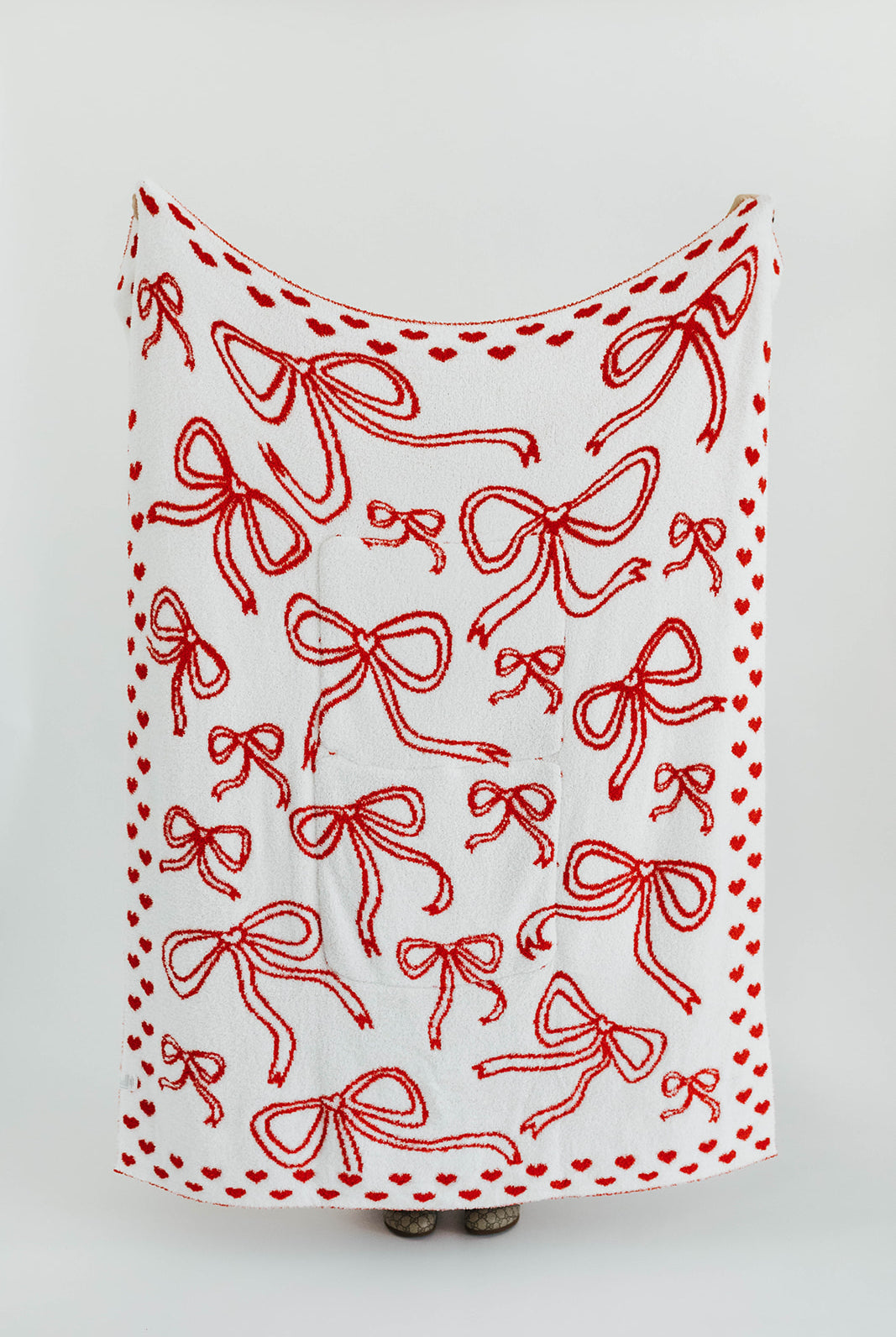 White blanket with red bow pattern on a white background