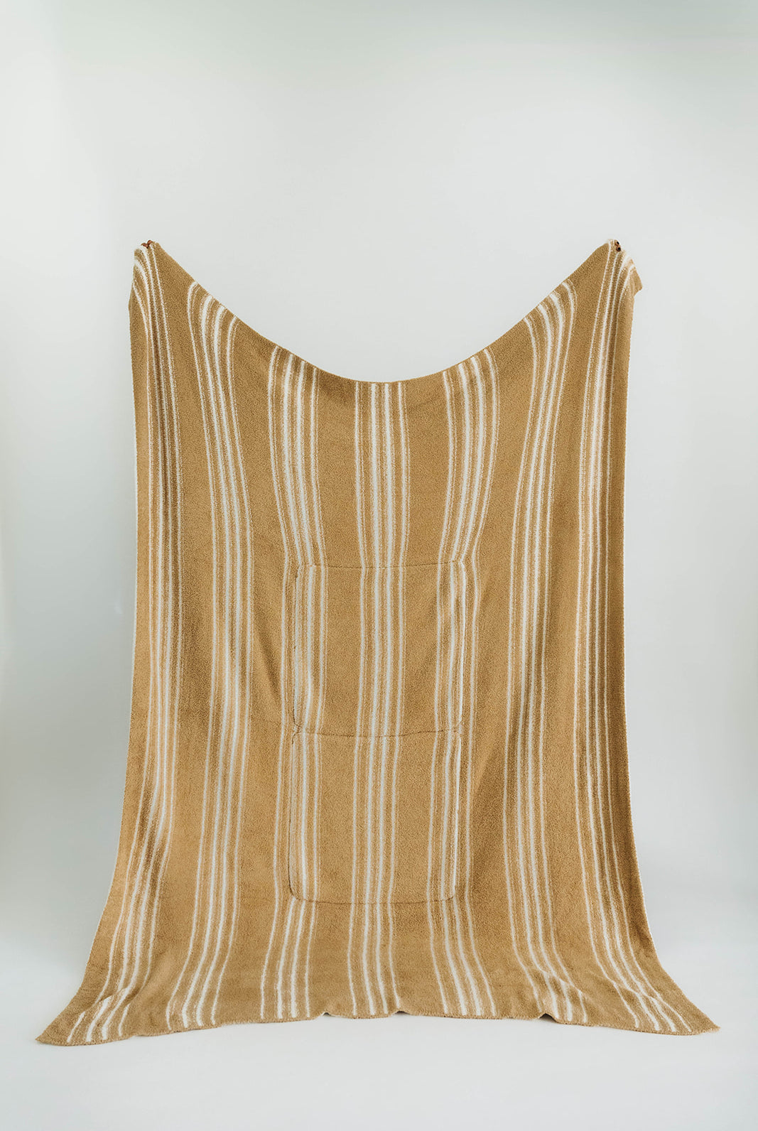 Striped brown and white blanket draped over a white background