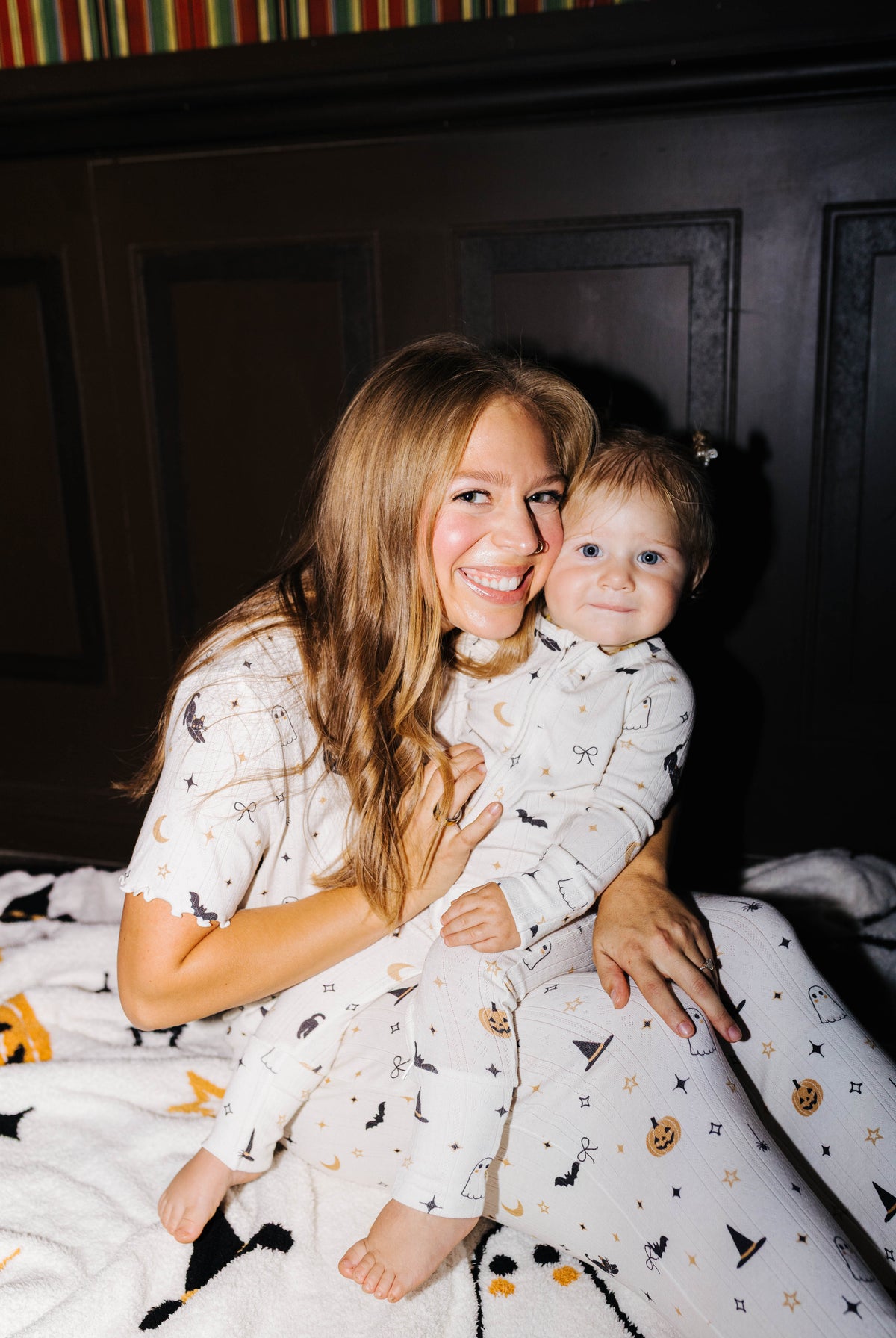 Adult and child in matching pajamas sitting on the Halloween Icon Print blanket