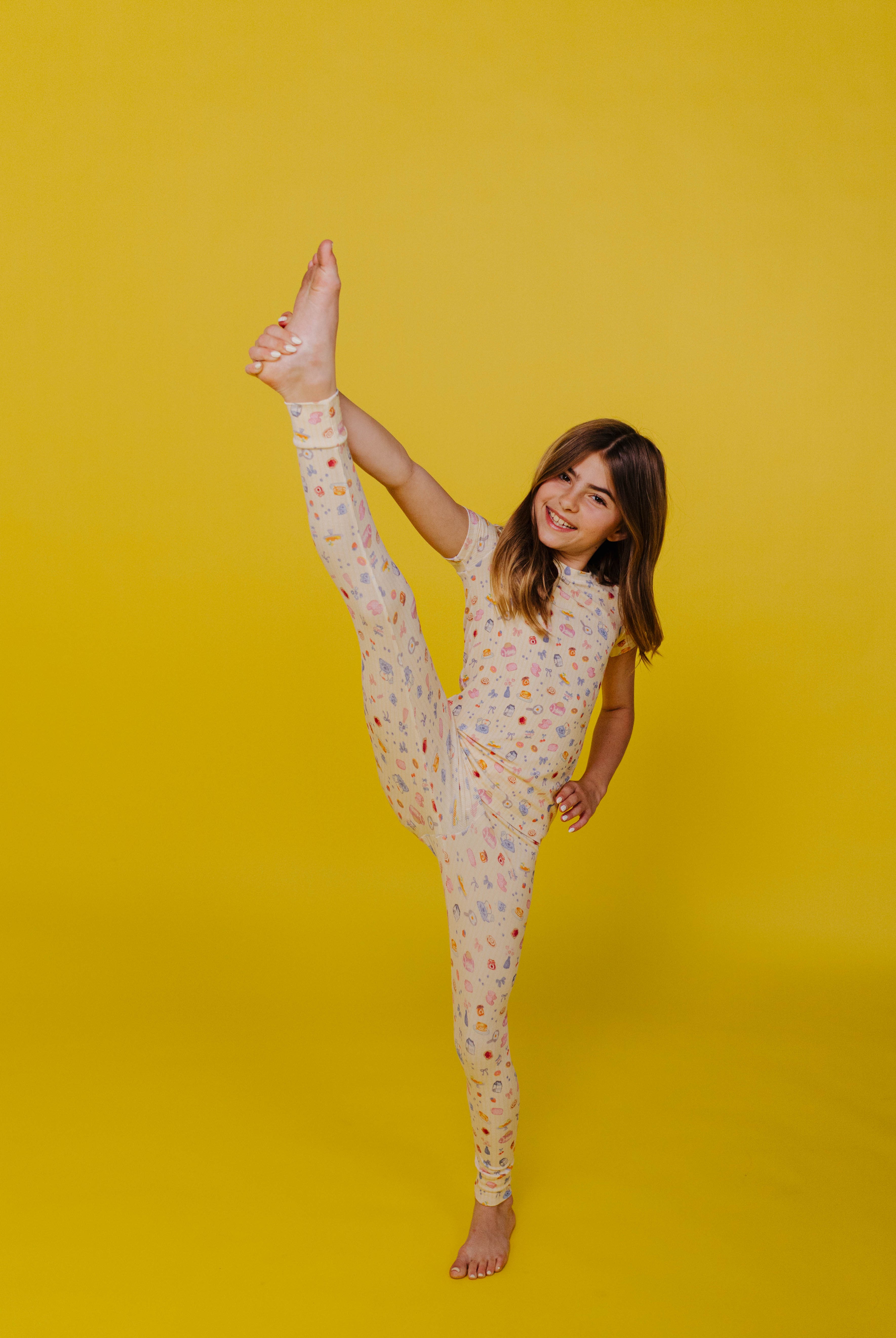 Kolly doing a toe touch on a yellow background