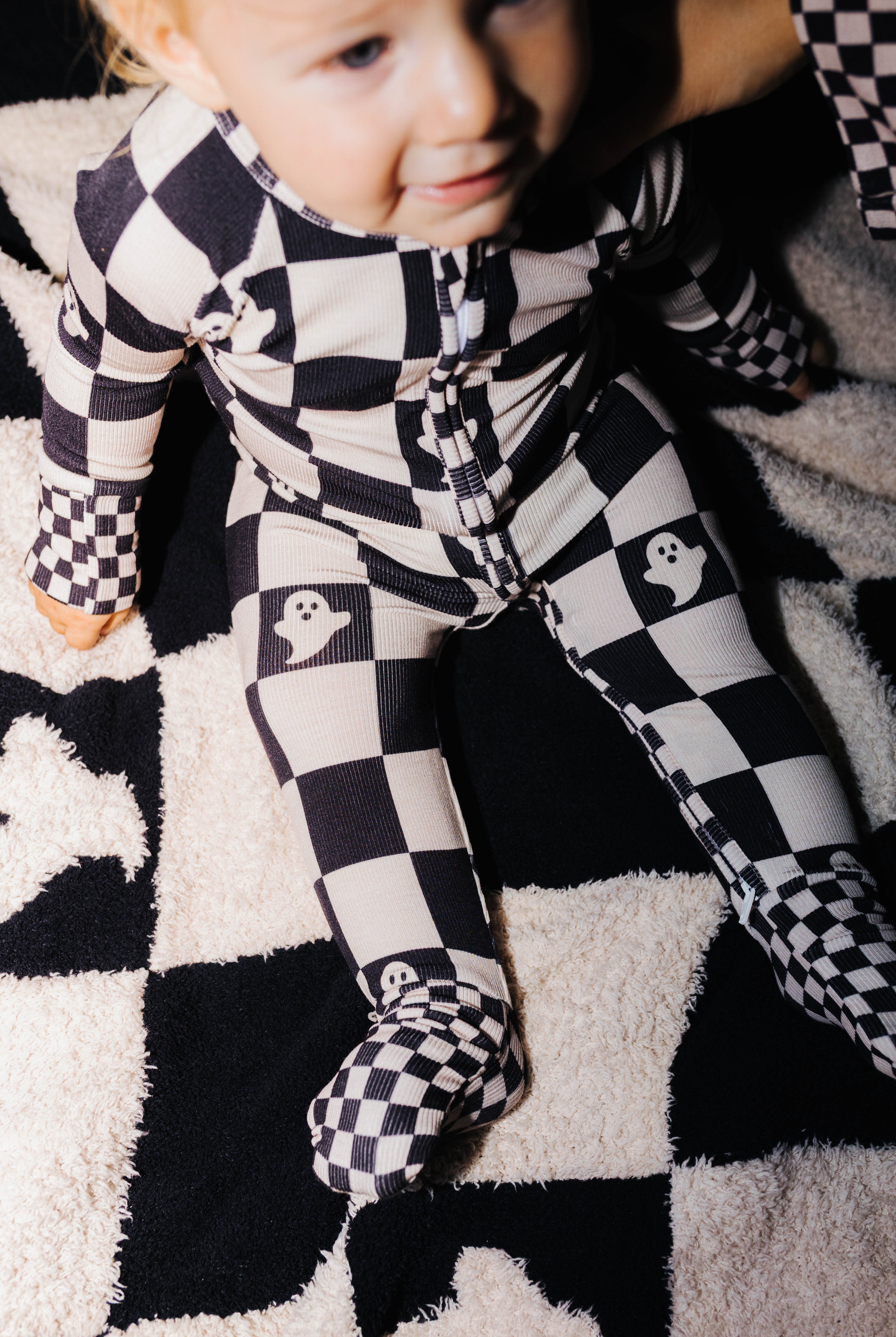 Close view of the zipper and collar on baby Ghost Check pajamas