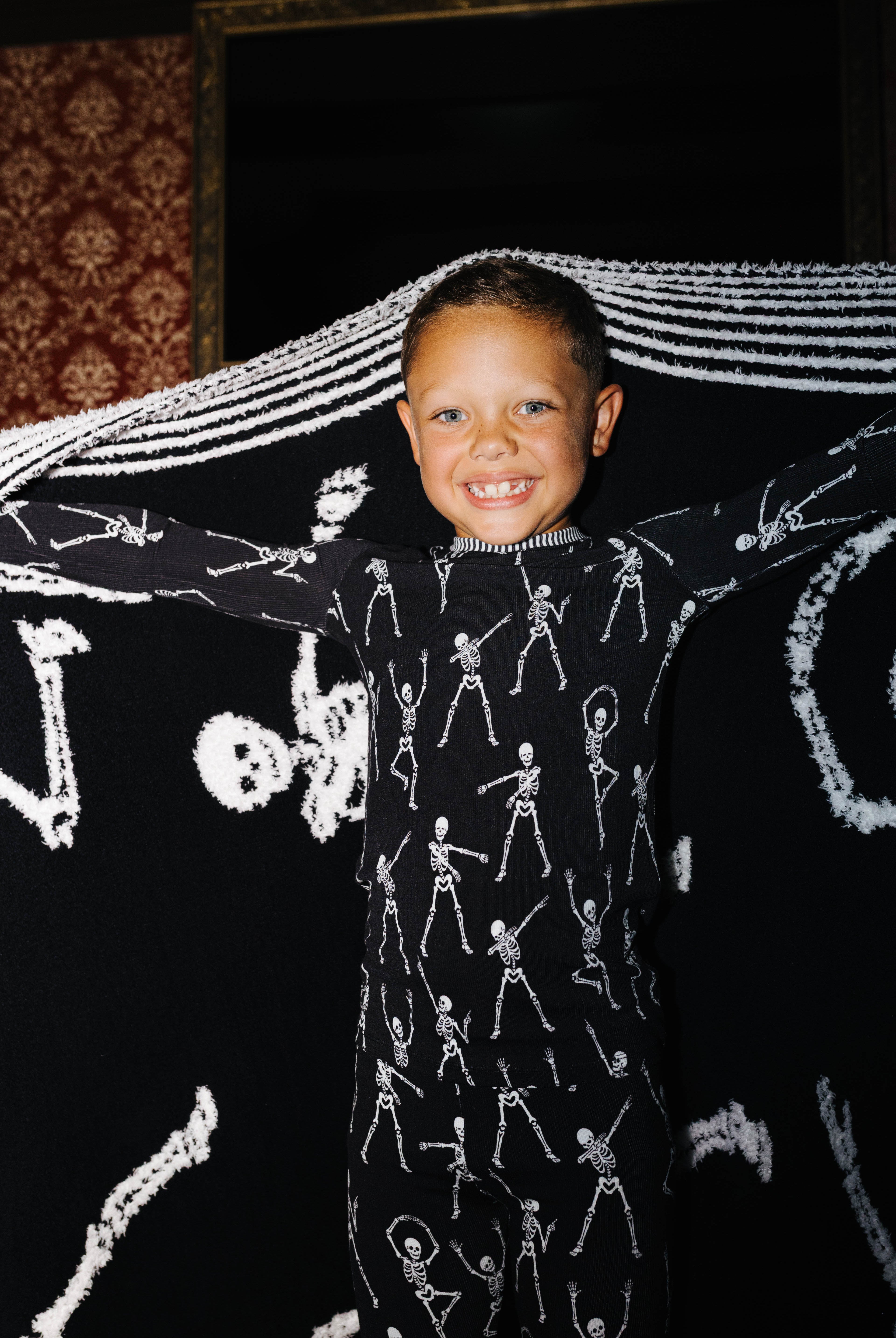 Child holding the Skelly blanket open