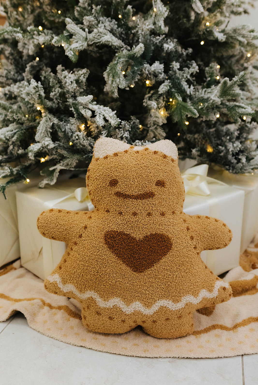 Gingerbread man plush toy with a heart on a Christmas-themed background