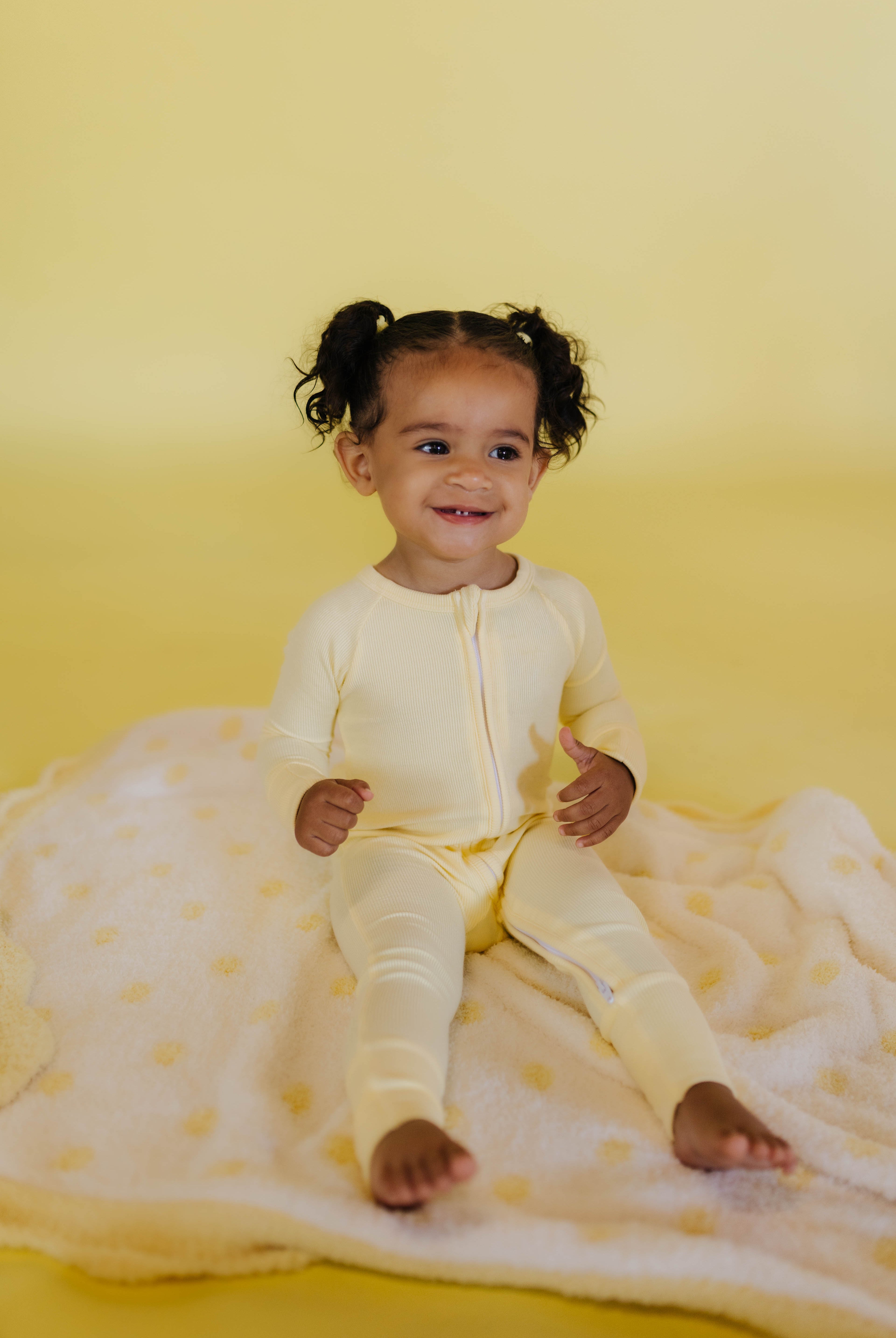 journiee sitting on the yellow polka kid blanket