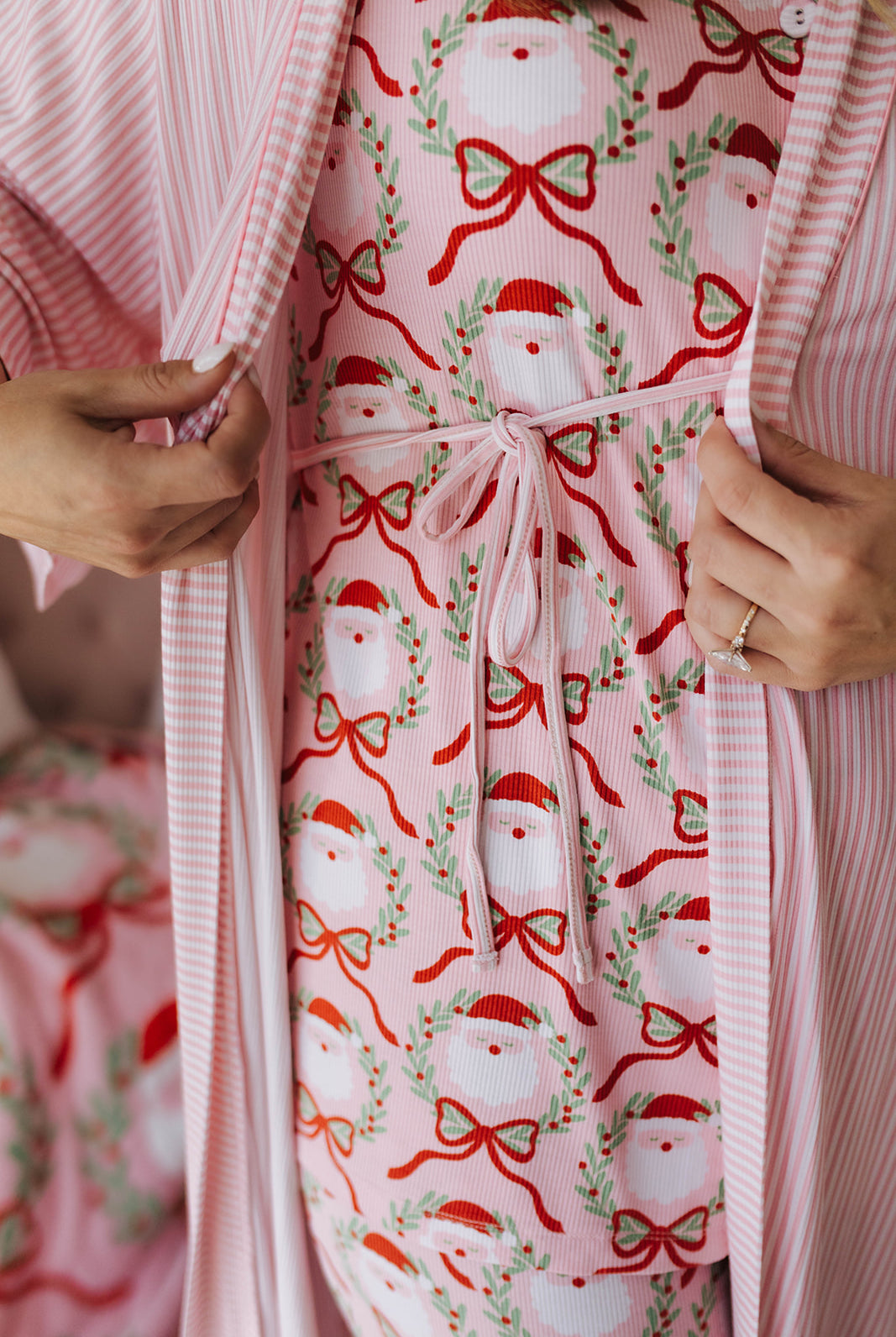 Pink robe with festive pattern featuring Santas and bows.