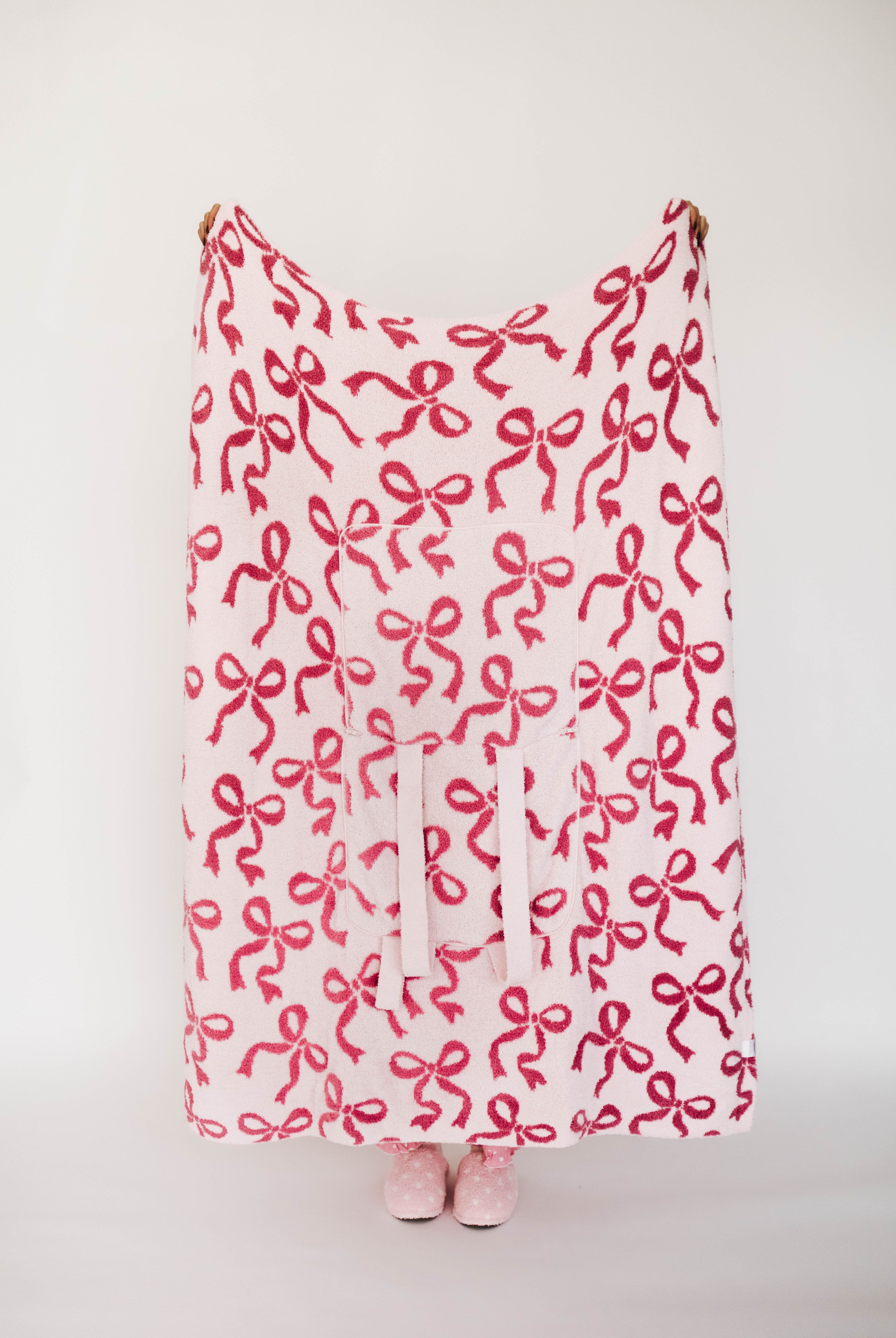 Pink blanket with bow pattern on a white background
