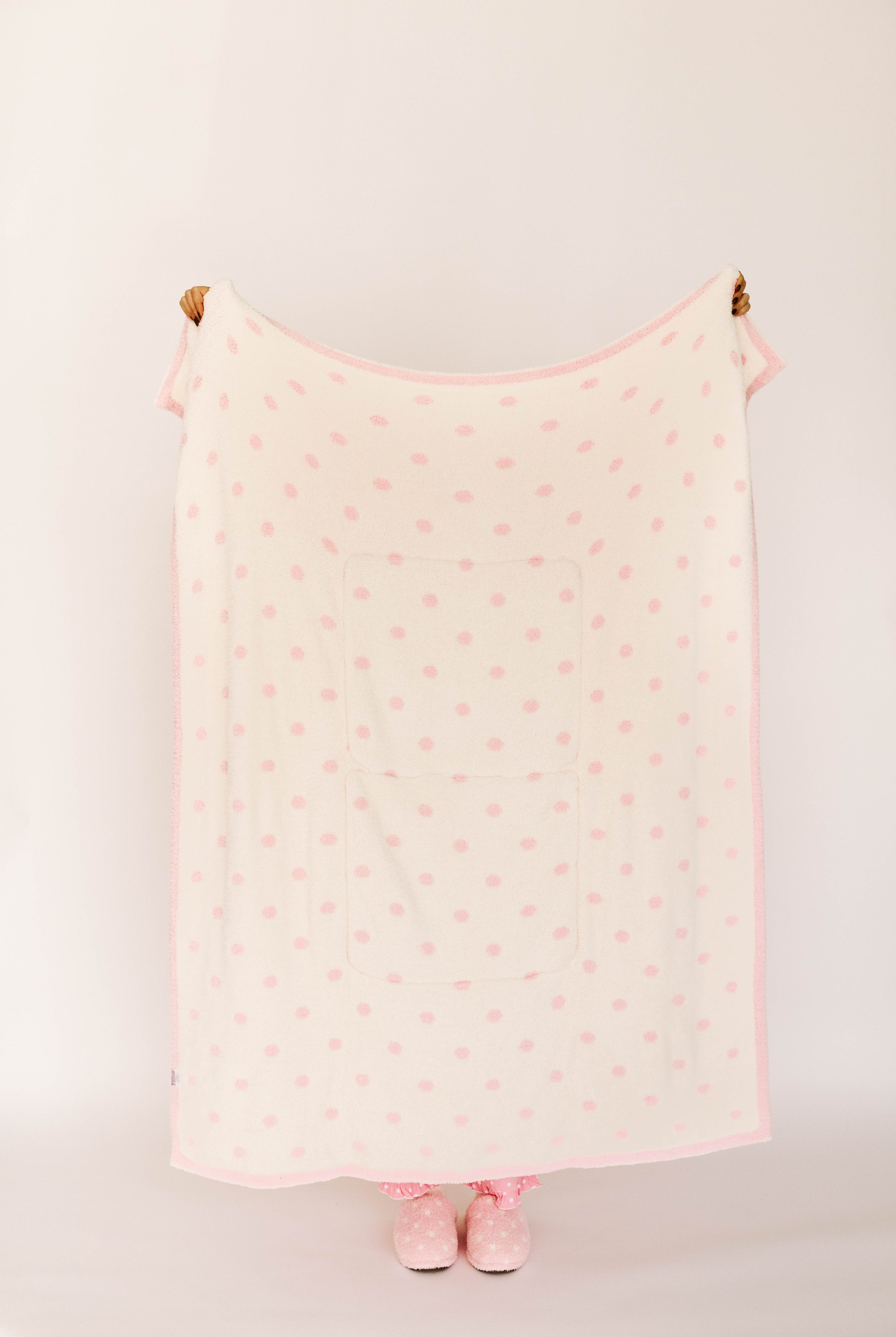 Pink polka dot blanket against a white background