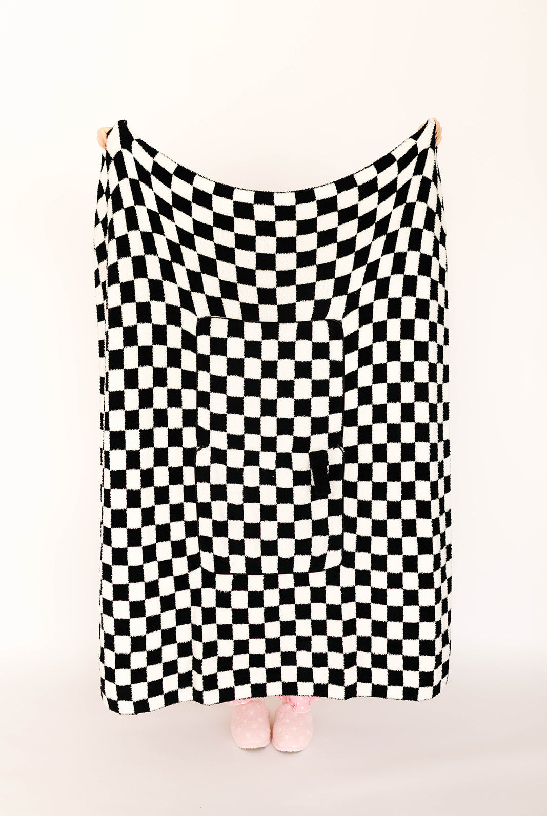 Black and white checkered blanket draped over a person on a white background