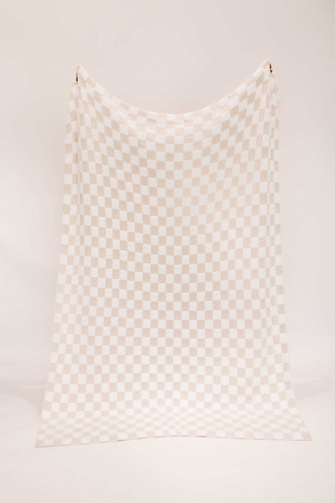 Checkered fabric with beige and white pattern on a white background