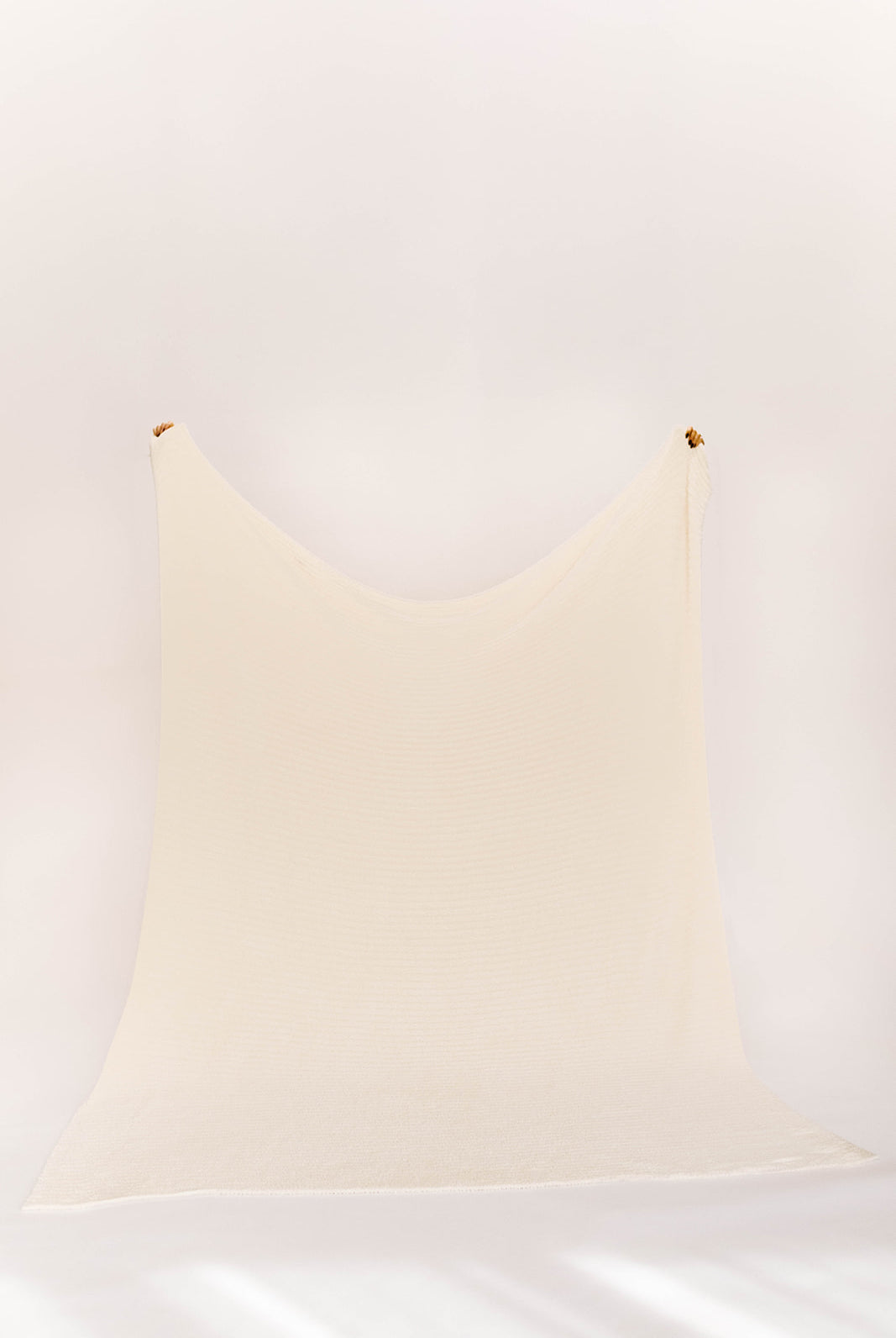 oversized cream blanket on a white wall